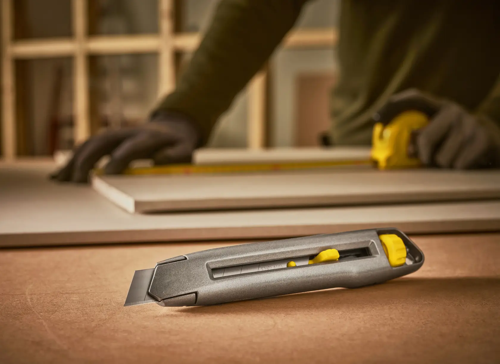 STANLEY 0-10-018 Universalmesser mit gelbem Schieber auf Tisch, Nahaufnahme, für Werkstattarbeiten.