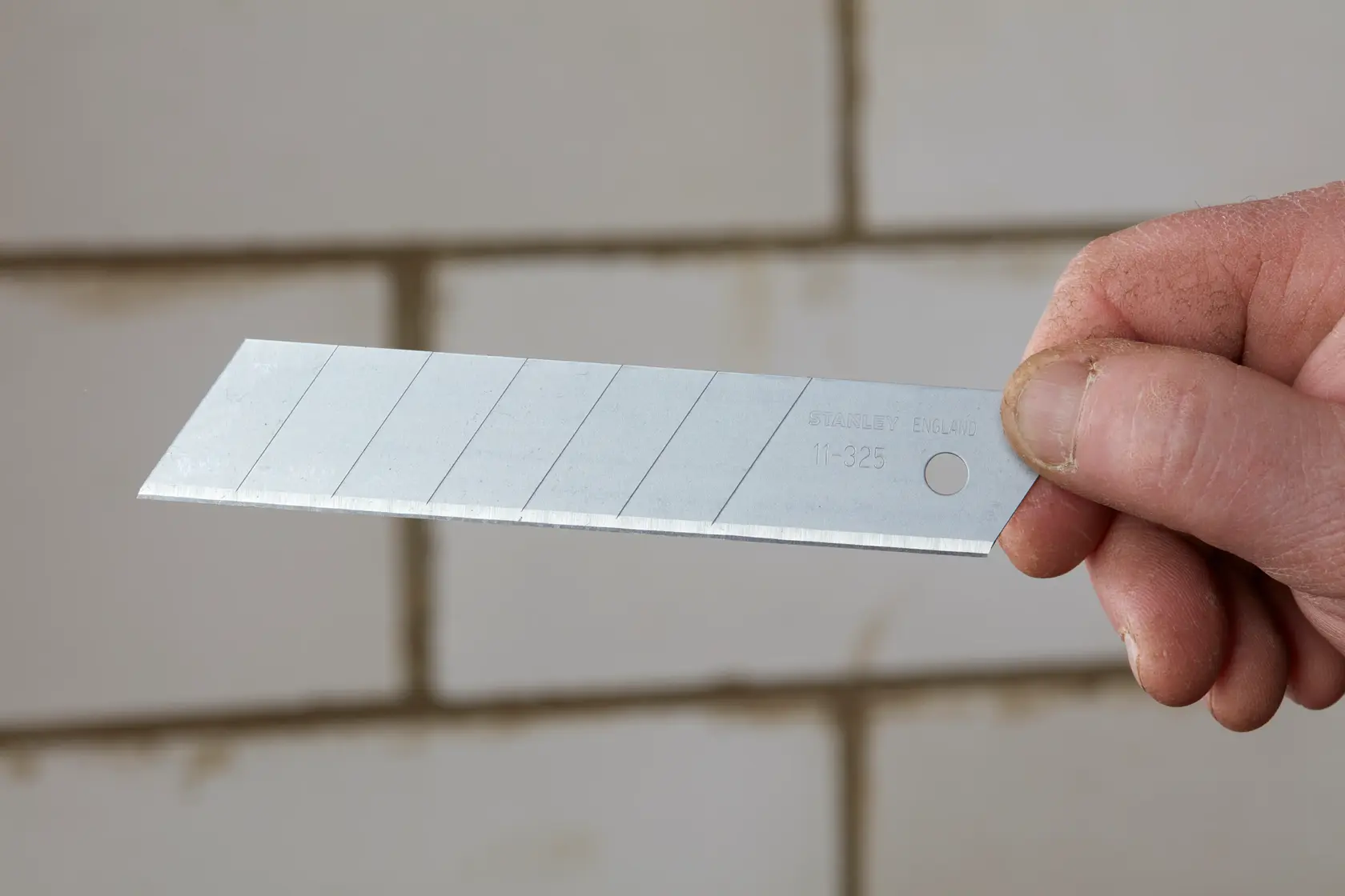 STANLEY 0-11-325 segmentiertes Abbrechmesser, silberfarben, in der Hand gehalten, Fotografie.