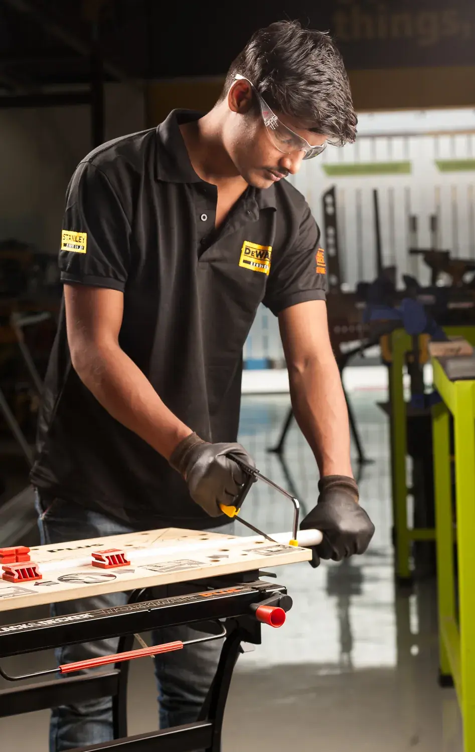 STANLEY 0-15-218 Bügelsäge Fotografie, Techniker mit schwarzem STANLEY Shirt sägt Holz in Werkstatt.