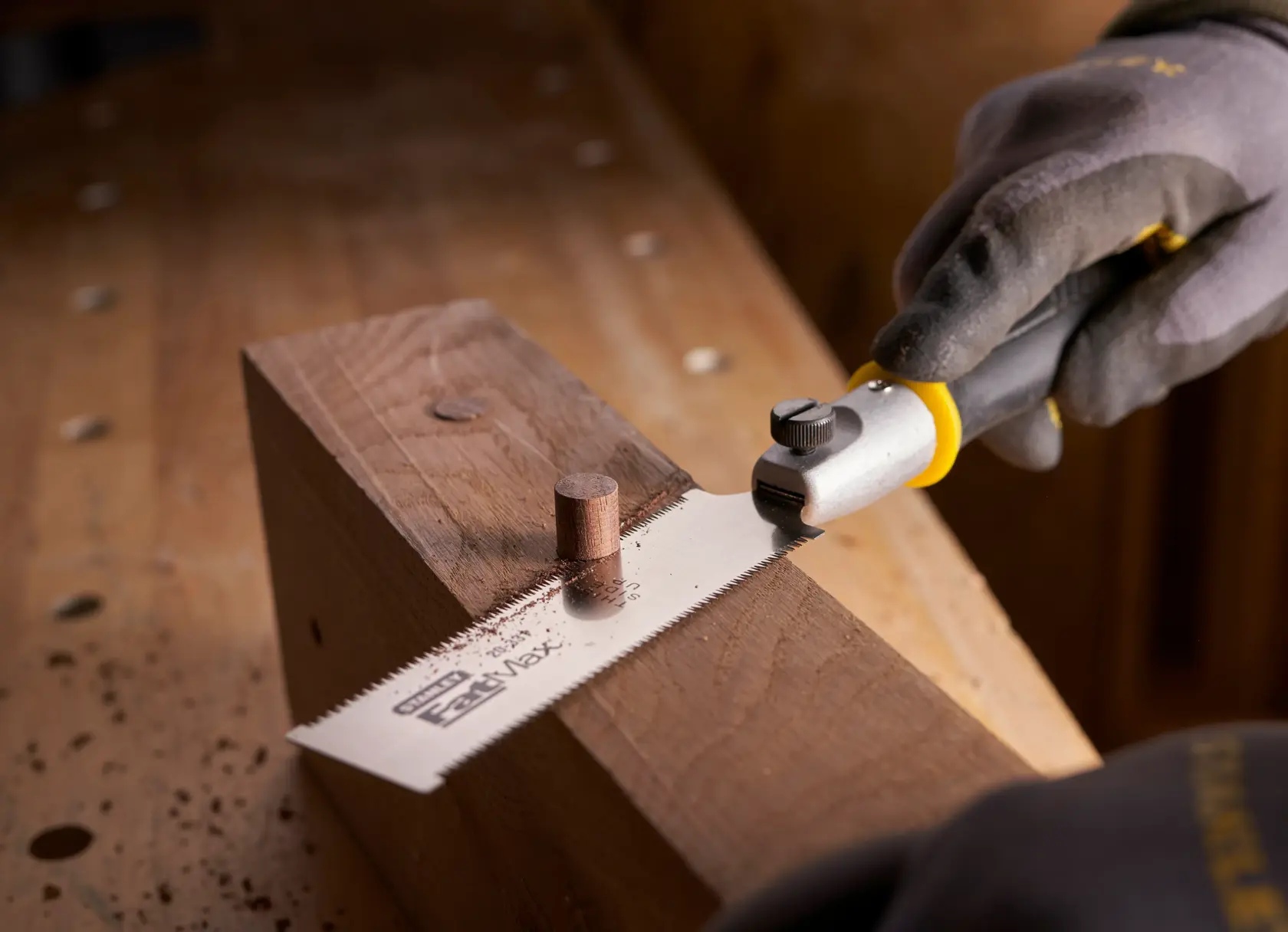 STANLEY 0-20-331 Flachschneidesäge schneidet Holzdübel auf Werkbank, Nahaufnahme.