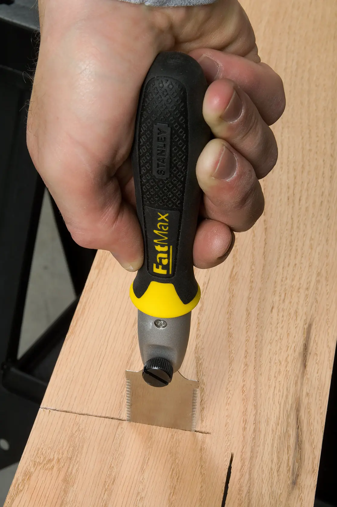 STANLEY 0-20-331 FatMax Säge mit schwarzem und gelbem Griff schneidet Holz, Nahaufnahme Fotografie.