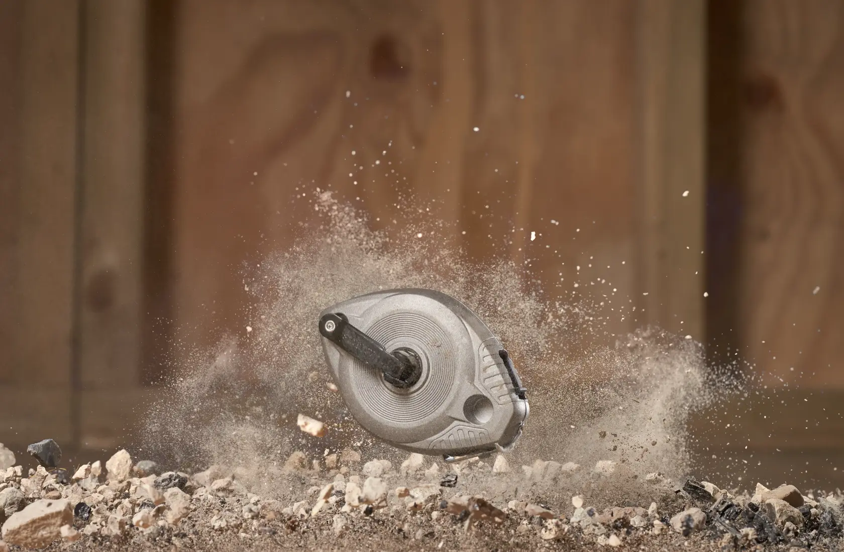 STANLEY 0-47-100 Schlagschnur-Fotografie in der Luft, umgeben von Staub und Kies, robuste Baustellenumgebung.
