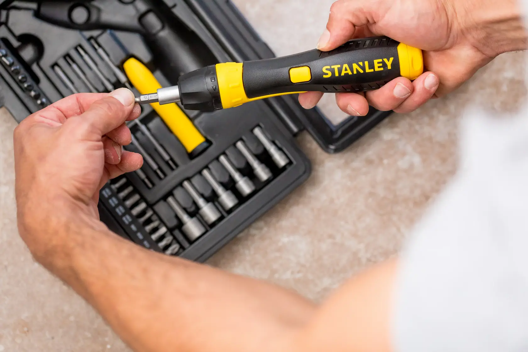 STANLEY 0-63-038 Ratschen-Schraubendreher-Set im Einsatz mit Bits und schwarzem Koffer auf Tisch.