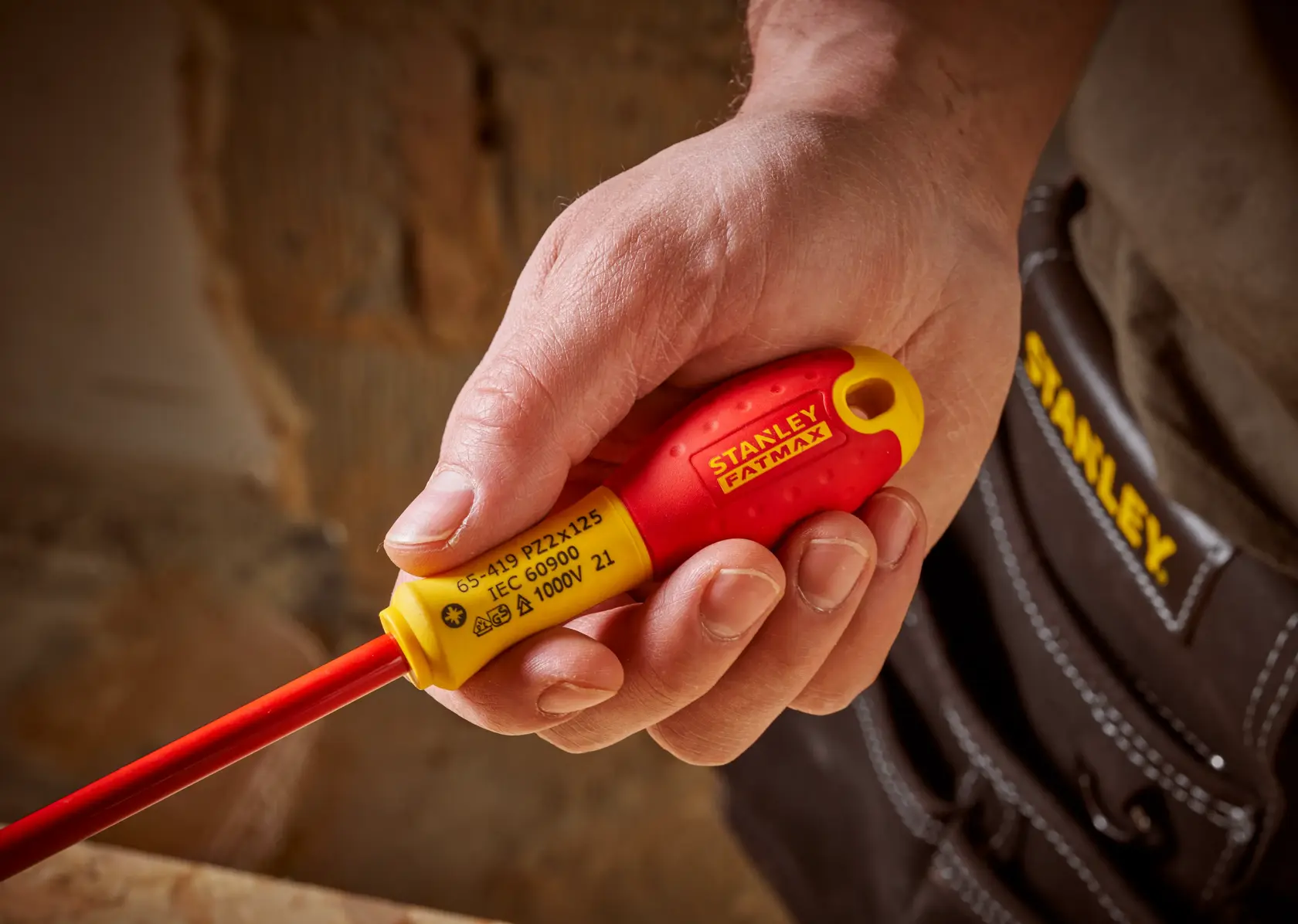 STANLEY 0-65-419 isolierter Schraubendreher mit rot-gelbem Griff in der Hand, Nahaufnahme.