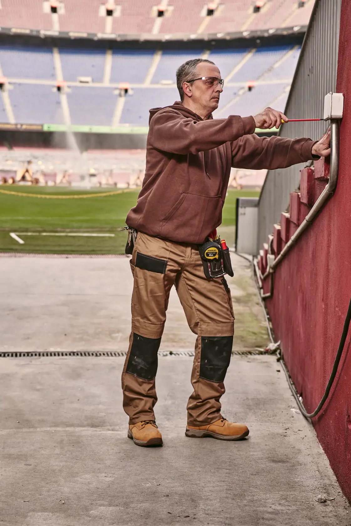 STANLEY 0-65-443 Schraubendreher von einem Arbeiter benutzt, um eine Außenelektrobox nahe einem Stadionfeld einzustellen.