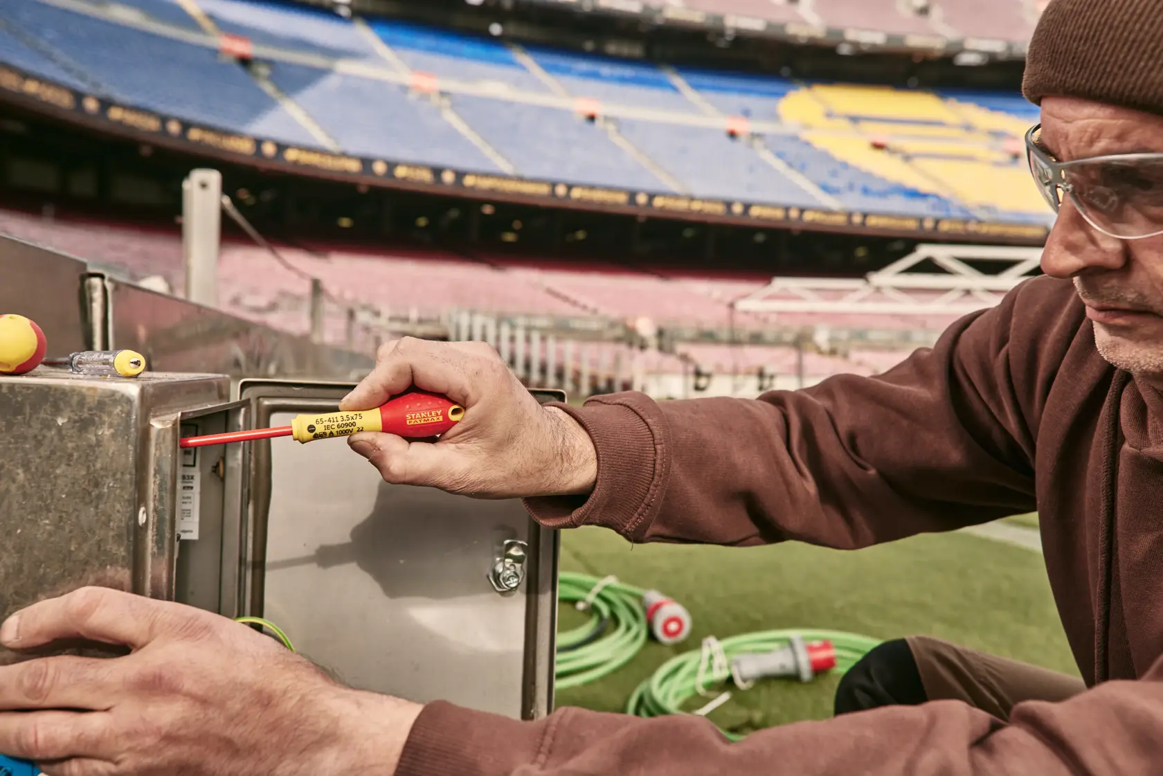 Foto des isolierten Schraubendrehers STANLEY 0-65-443 bei der Anwendung an einem Metall-Elektrokasten im Stadion.