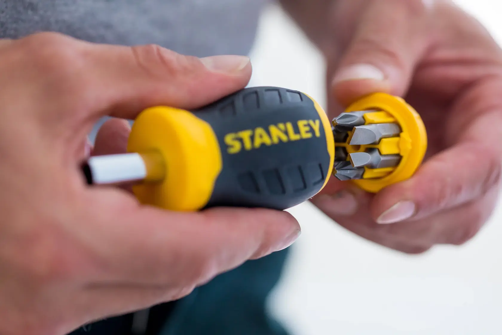 STANLEY 0-66-357 Schraubendreher mit gelb-schwarzem Griff, Bitfach offen in Hand gezeigt.
