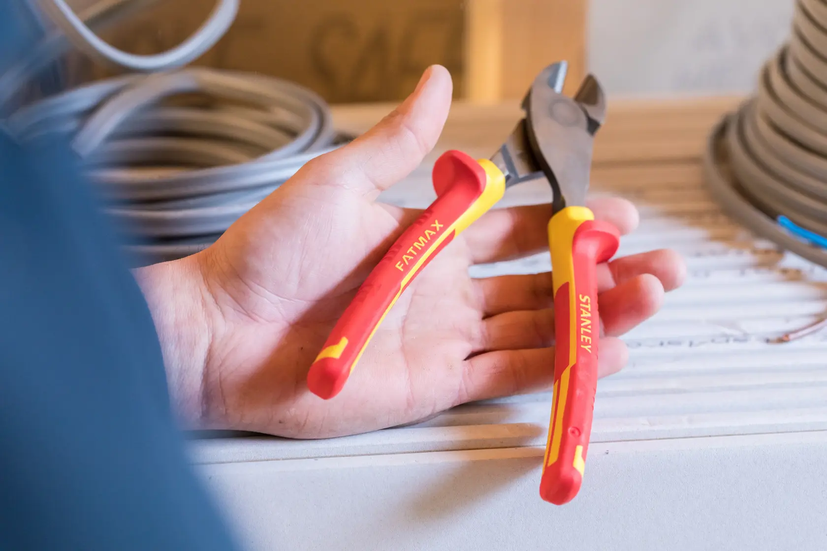 Stanley 0-84-004 isolierte Zange mit rot-gelben Griffen, in der Hand gehalten, Nahaufnahme.
