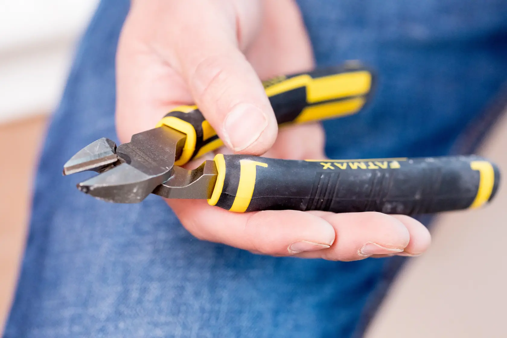 Foto der STANLEY 0-89-858 diagonalen Seitenschneider mit schwarzem und gelbem Griff, in der Hand gehalten.