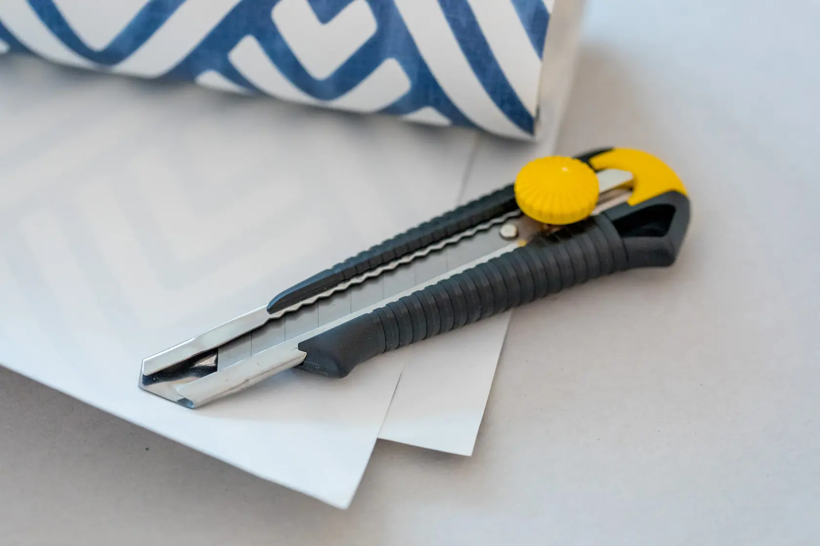 STANLEY 1-10-418 Universalmesser mit schwarz-gelbem Griff auf Papier, Seitenansicht.