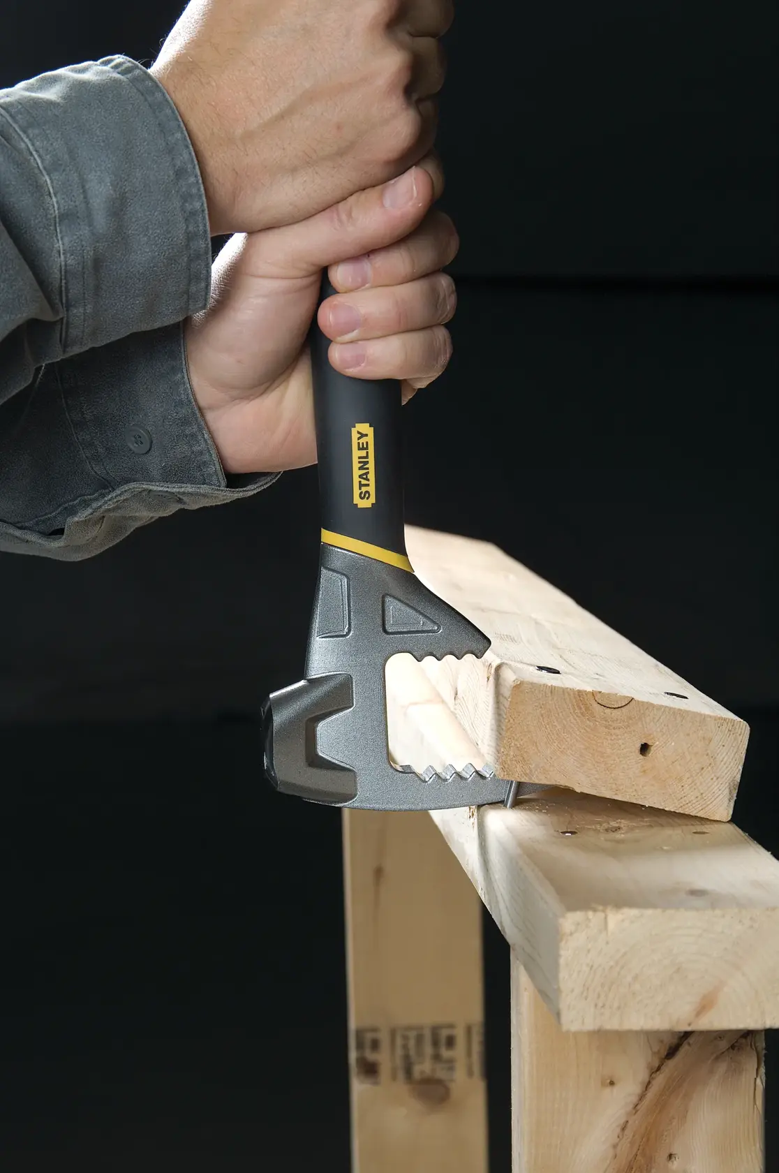 STANLEY 1-55-099 Abbruchwerkzeug wird von Hand gehalten und reißt Holz, Nahaufnahme.