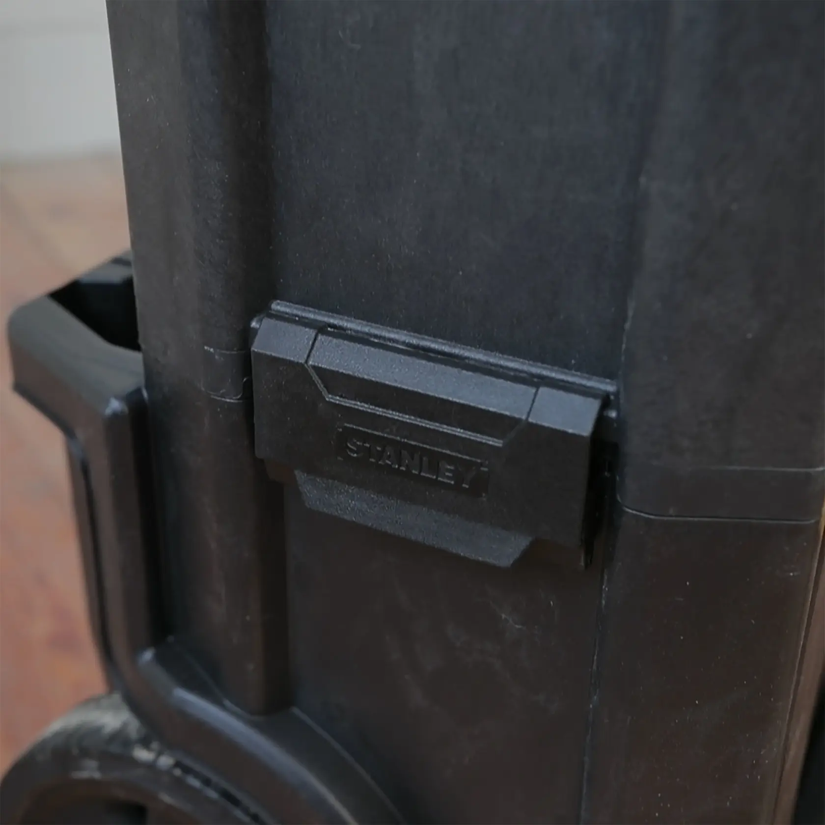 Foto von STANLEY 1-79-206 Werkzeugkastenriegel, Nahaufnahme mit schwarzem Kunststoff und Logo.