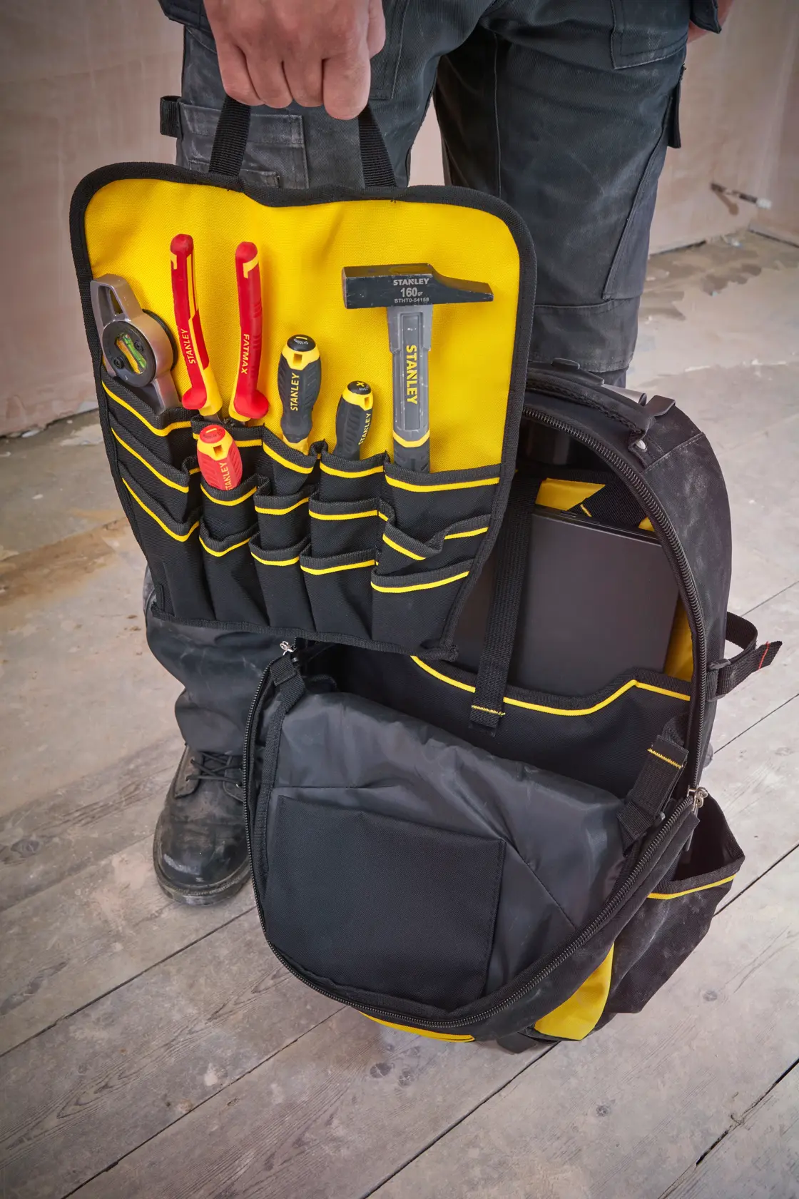 STANLEY 1-79-215 Werkzeugrucksack offen, gelbe und schwarze Taschen mit Handwerkzeugen, Vorderansicht.