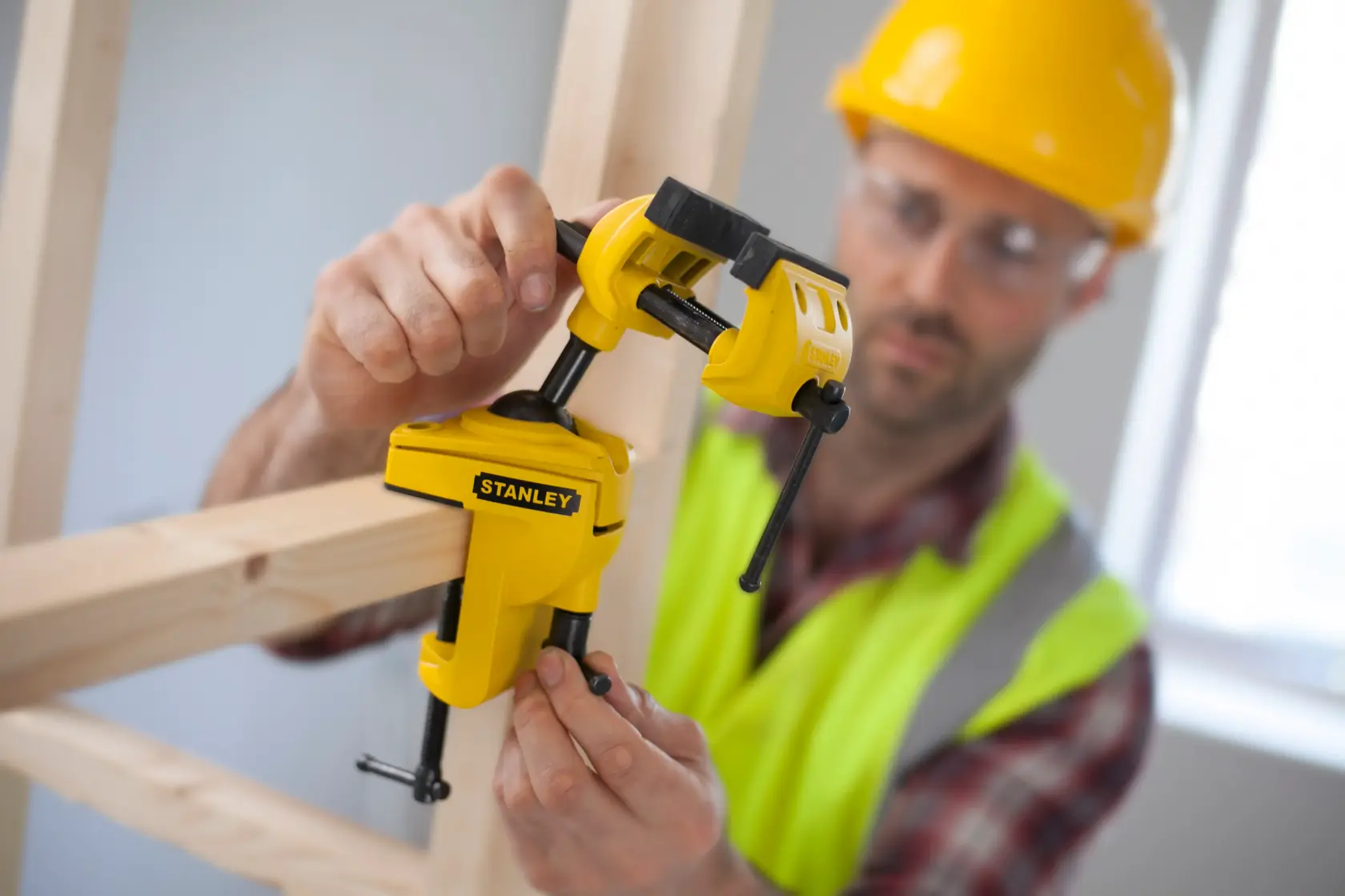 STANLEY 1-83-069 Holzspanner im Einsatz, Arbeiter befestigt Holzrahmen, Nahaufnahme.