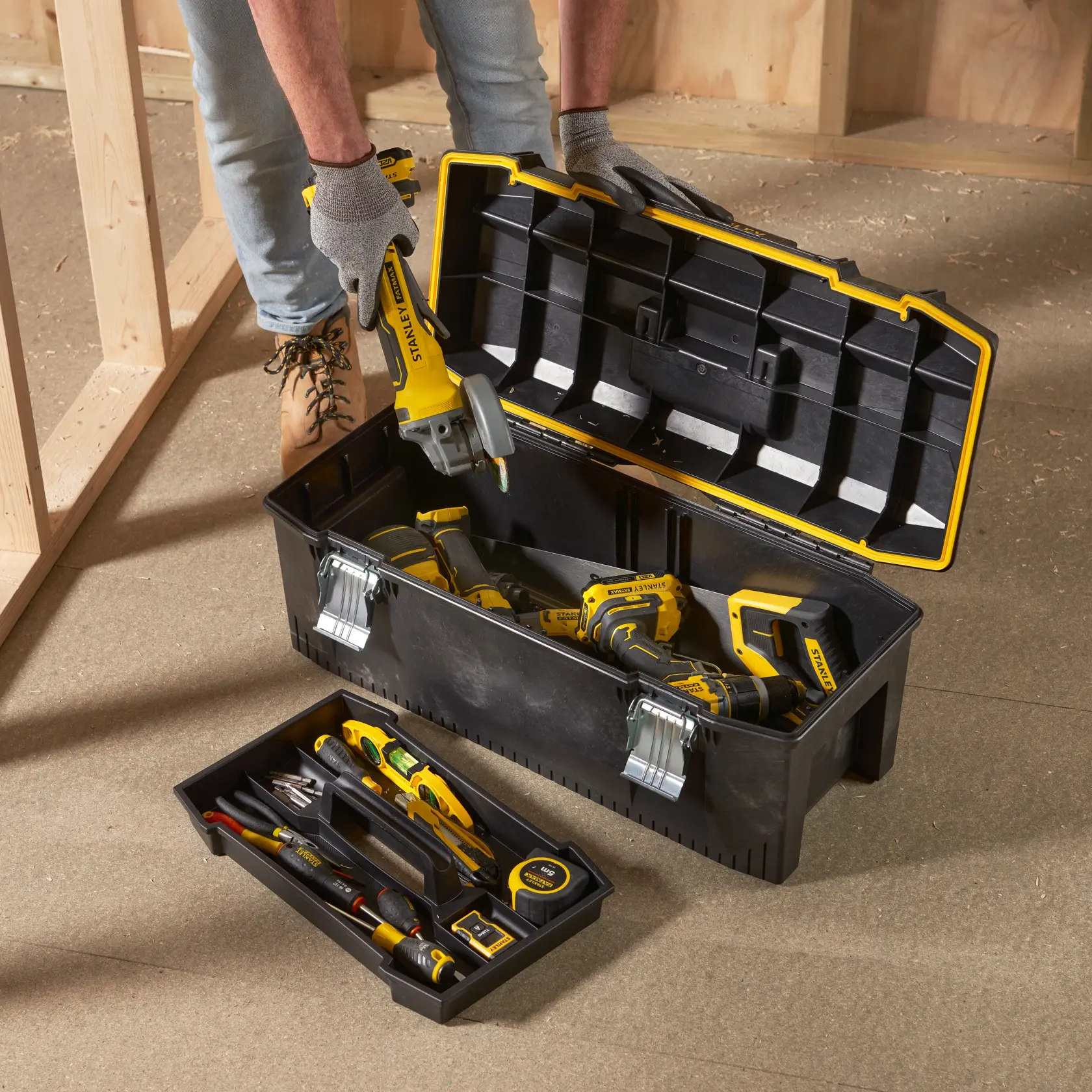 STANLEY 1-93-935 Werkzeugkasten mit Hand- und Elektrowerkzeugen, geöffnet auf Werkstattboden, Aufnahme von oben.
