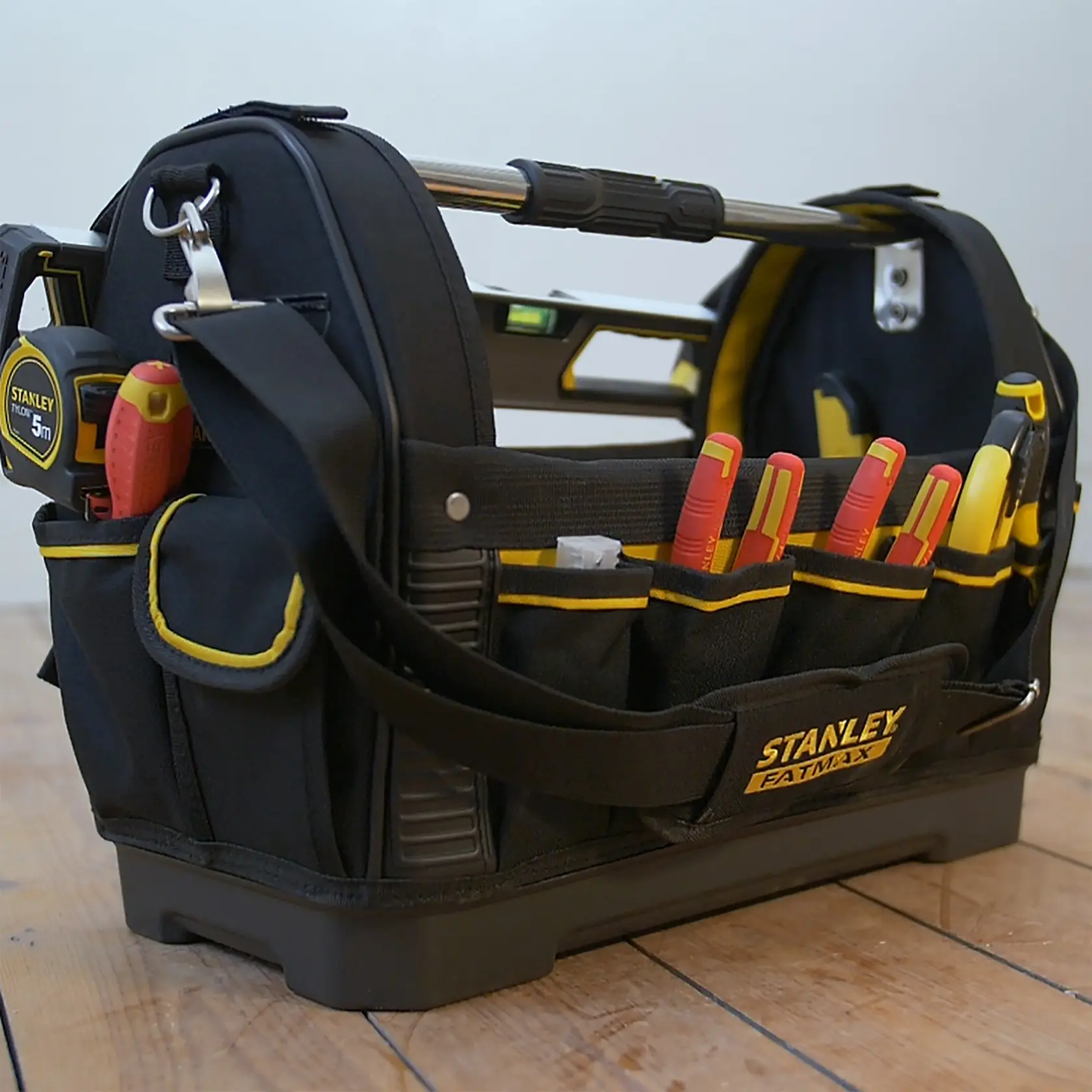 STANLEY 1-93-951 FATMAX Werkzeugtasche mit Werkzeugen, Seitenansicht, schwarz-gelb auf Holzboden.