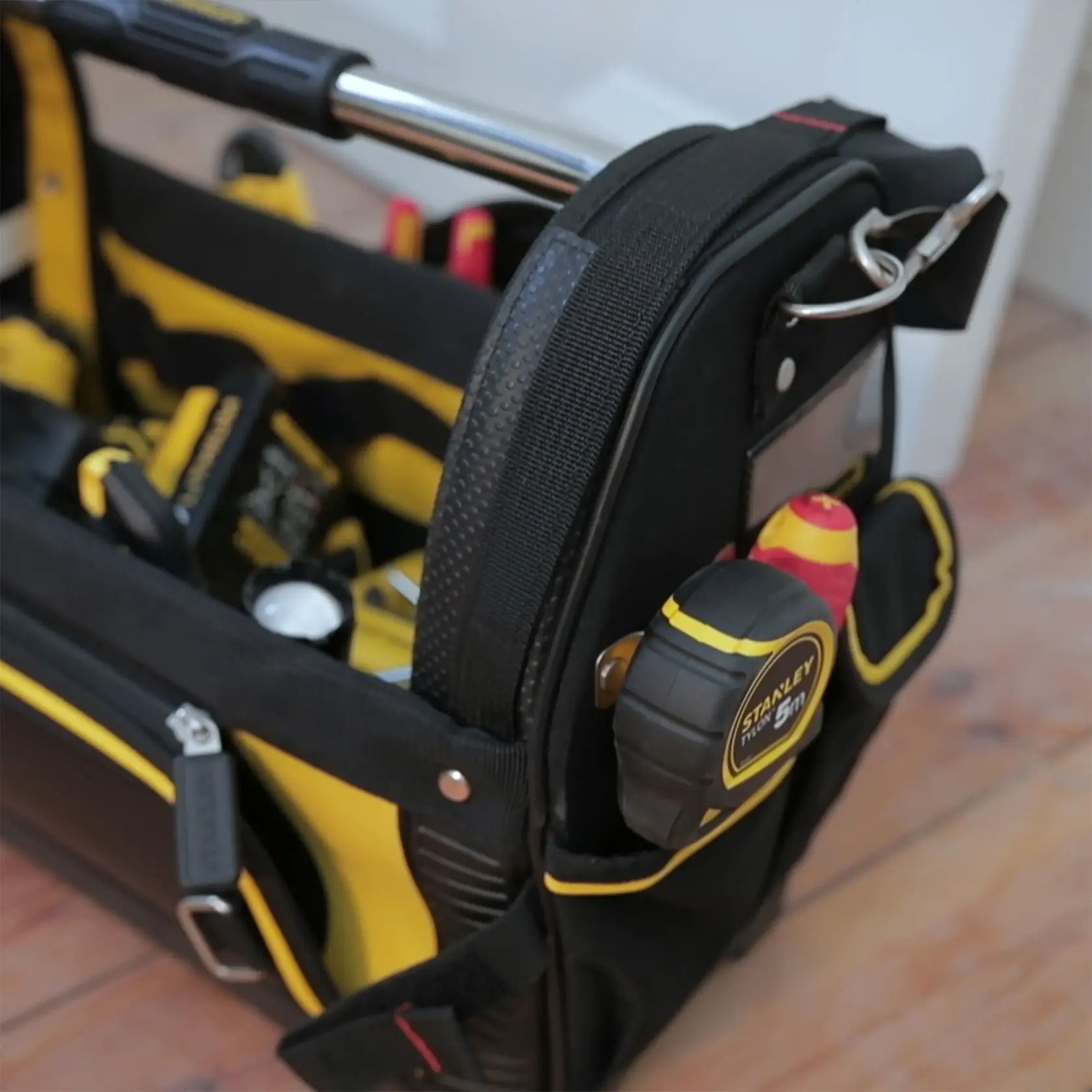 STANLEY 1-93-951 Werkzeugtasche mit gelben und schwarzen Details, voller Werkzeuge, Seitenansicht Nahaufnahme.
