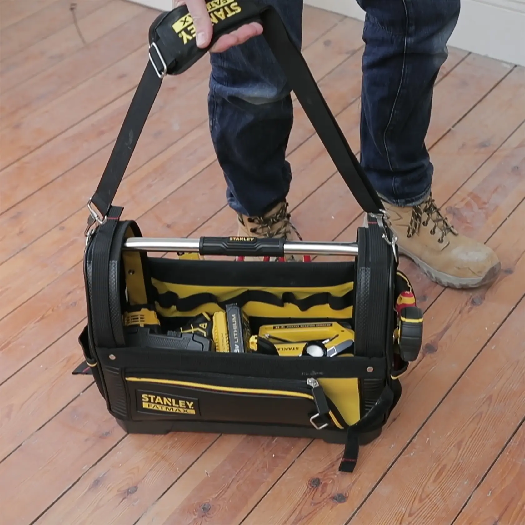 STANLEY 1-93-951 Werkzeugtasche mit Schultergurt, gefüllt mit Werkzeugen, auf Holzboden fotografiert.