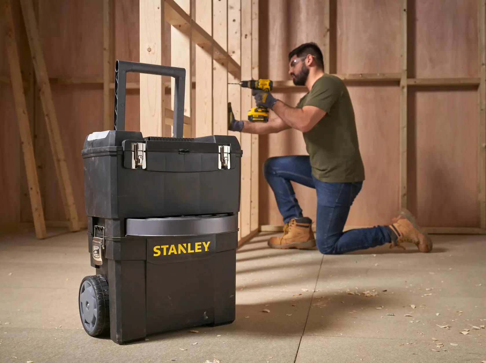 Stanley 1-93-968 Rollwerkzeugkasten im Werkstatt, Vorderansicht, schwarz mit gelbem Logo, mit Verschlüssen.