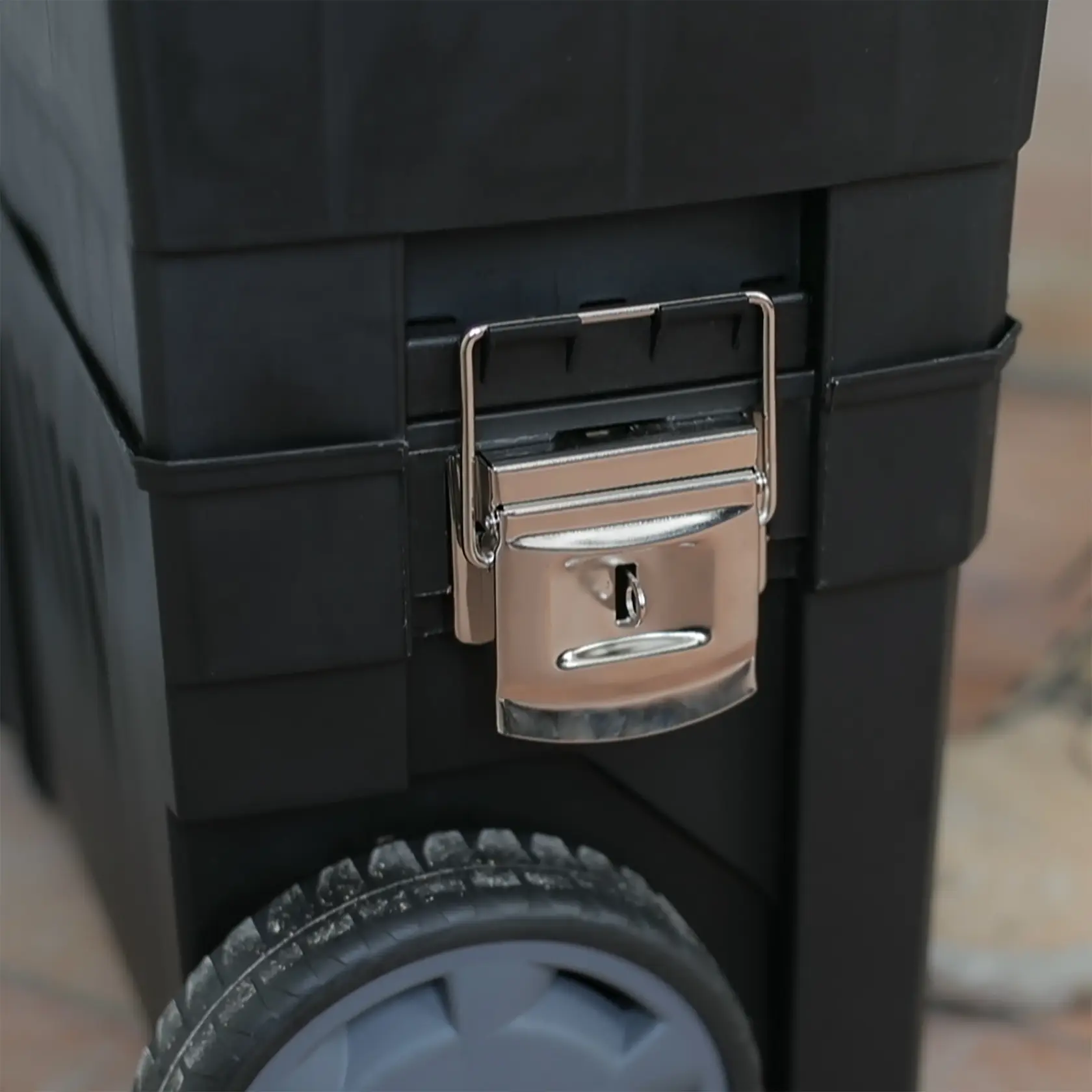STANLEY 1-93-968 schwarze Werkzeugbox auf Rädern, Nahaufnahme vom Metallschloss und Rad.