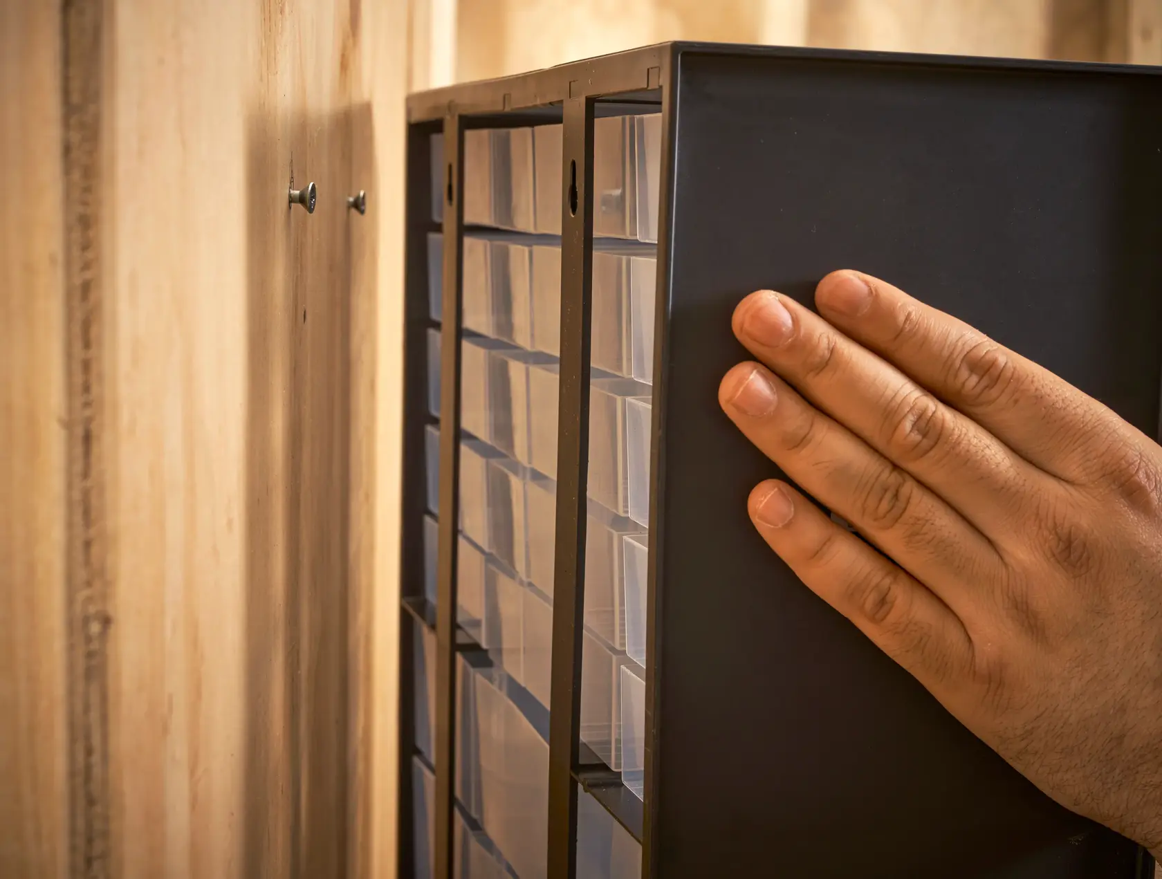STANLEY 1-93-981 Aufbewahrungsbox wird per Hand an die Wand montiert, Nahaufnahme seitlich.