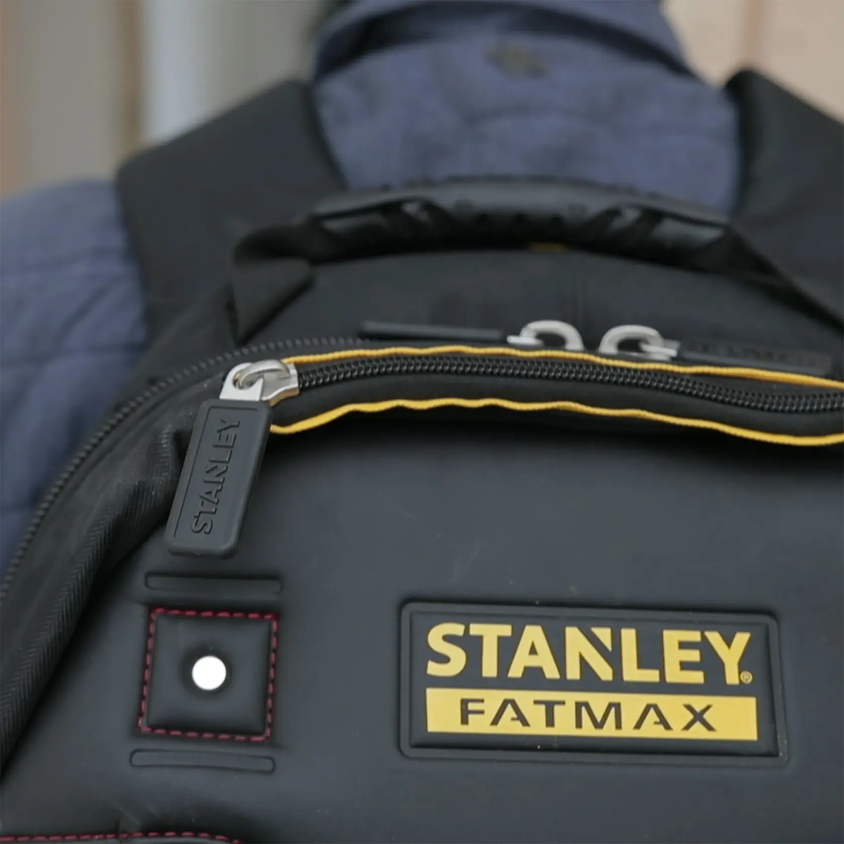 STANLEY 1-95-611 Fotografie FATMAX schwarzer Rucksack vorne, gelbes Logo, sichtbarer Reißverschluss.