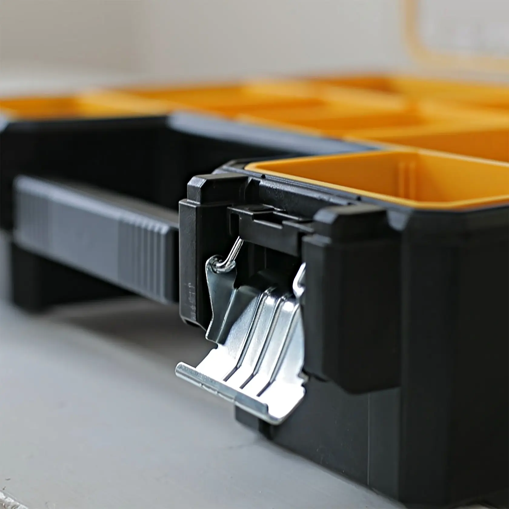 STANLEY 1-97-518 Organizer-Box mit gelben Fächern, Nahaufnahme des Metallverschlusses, Produkt schräg auf weißem Hintergrund.