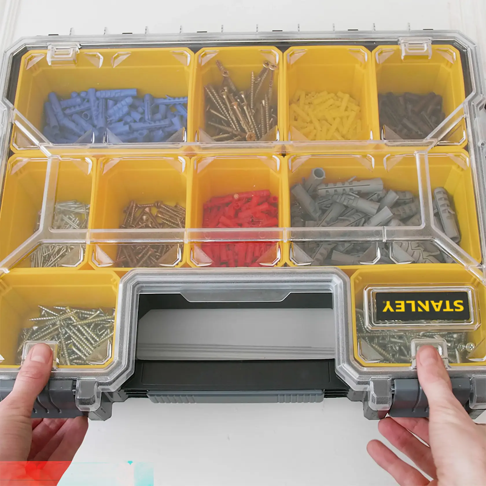 STANLEY 1-97-521 Organizer-Box mit gelben Fächern, Klarsichtdeckel, Schrauben und Dübeln, Draufsicht.