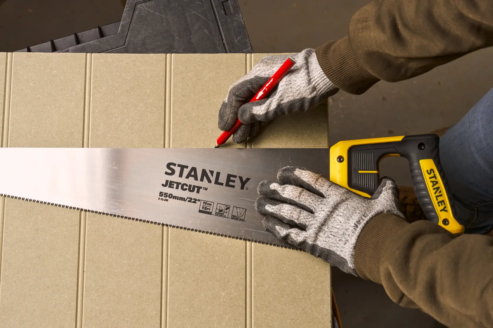 Foto der STANLEY 2-15-244 Handsäge mit gelbem Griff und JETCUT Klinge, zum Anzeichnen einer Schnittlinie auf Holz.