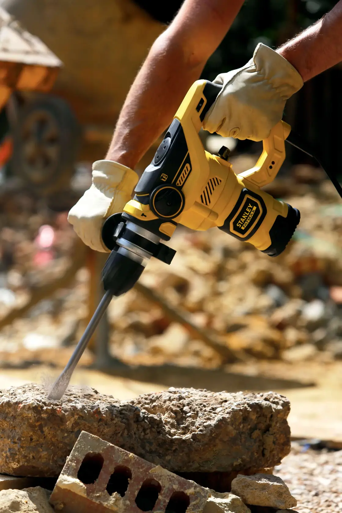 STANLEY FME1250K Bohrhammer in Gebrauch, gelb-schwarzes Design, bohrt in Beton auf Baustelle.