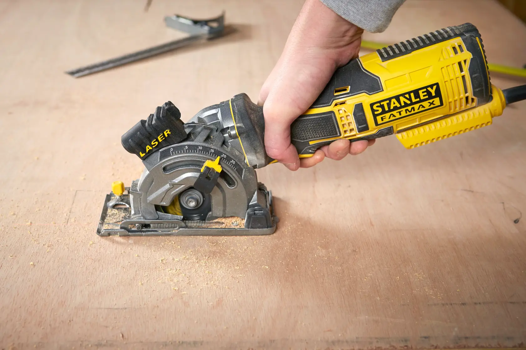 Foto der STANLEY FME380K Handkreissäge mit Laserführung im Einsatz auf einer Holzfläche.