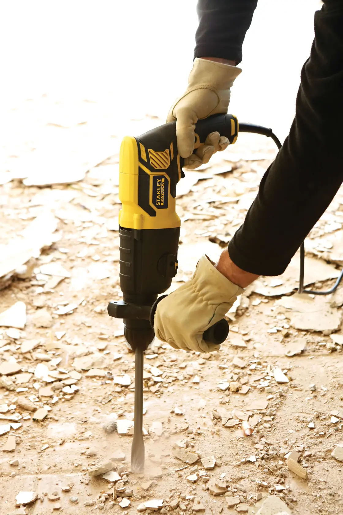 STANLEY FME500K Abbruchhammer im Einsatz auf Schuttboden, Arbeiter trägt Handschuhe.