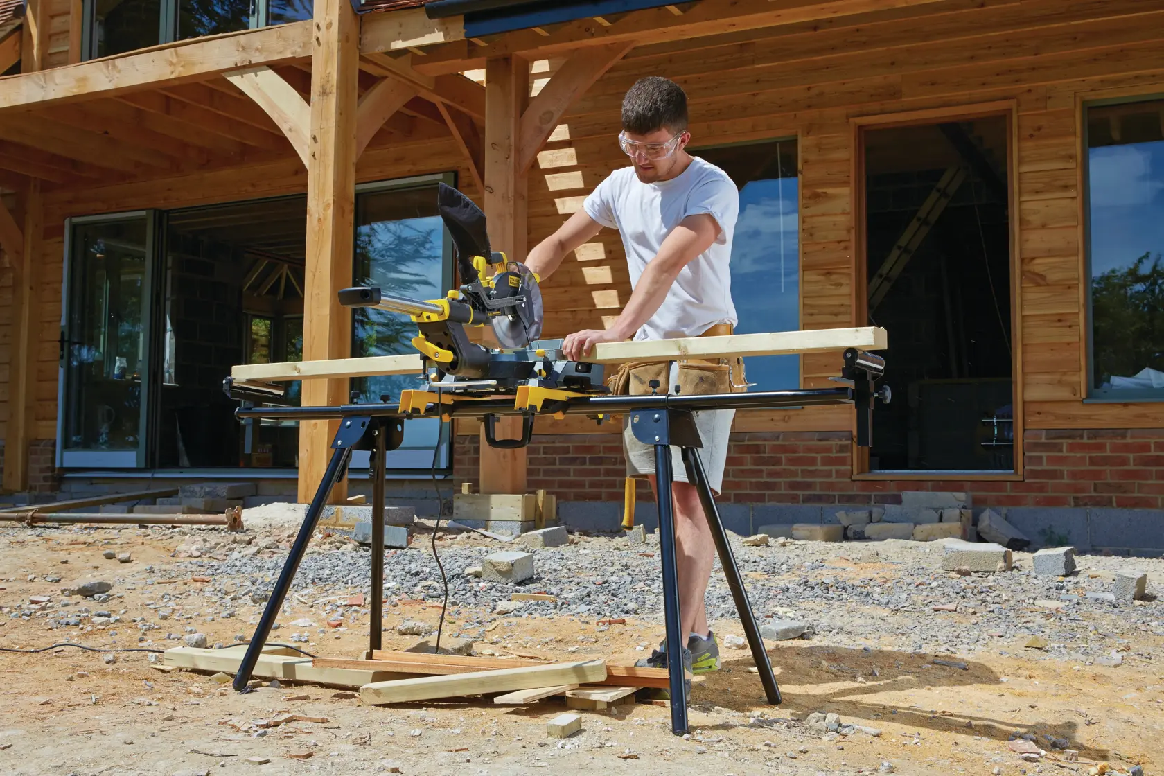 STANLEY FME721-QS Gehrungssäge im Einsatz im Freien auf einer Baustelle, auf einem Ständer positioniert, schneidet Holz.