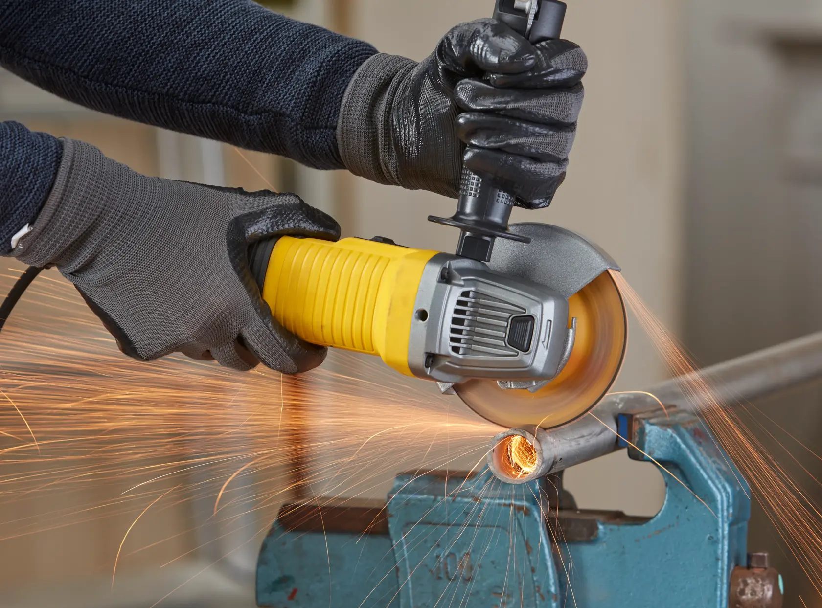 STANLEY FMEG220 Winkelschleifer schneidet Metallrohr, Nahaufnahme mit sichtbaren Funken.