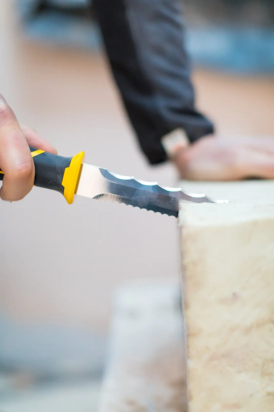 Foto von STANLEY FMHT0-10327 Dämmstoffmesser mit schwarz-gelbem Griff schneidet Schaumplatte.