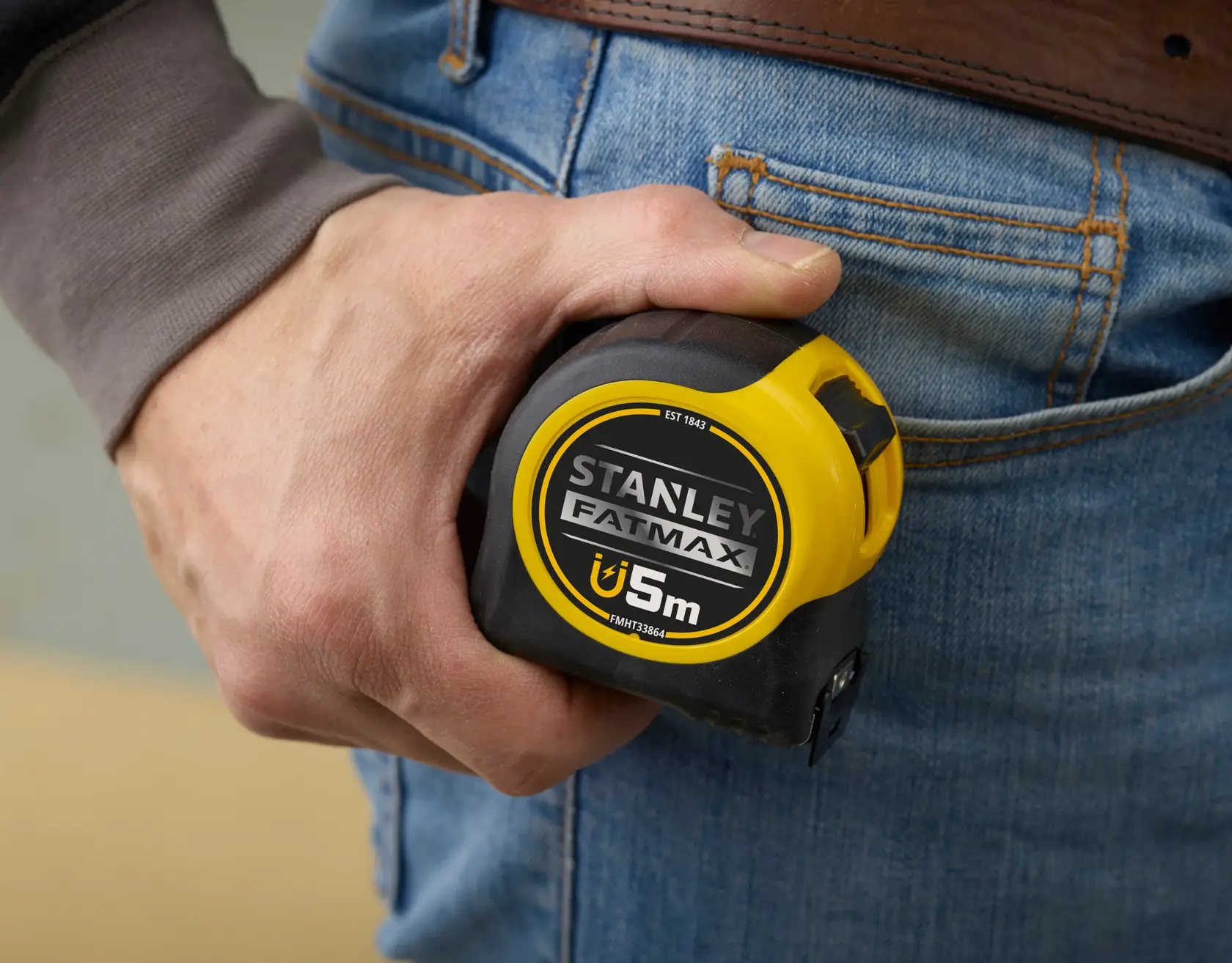 Stanley FMHT0-33864 Maßband in der Hand gehalten, gelb und schwarz, Nahaufnahme.