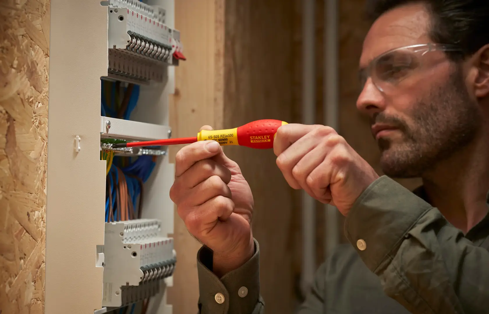 Fotografie des STANLEY FMHT0-62649 isolierten Schraubendrehers bei elektrischen Panelkabeln.