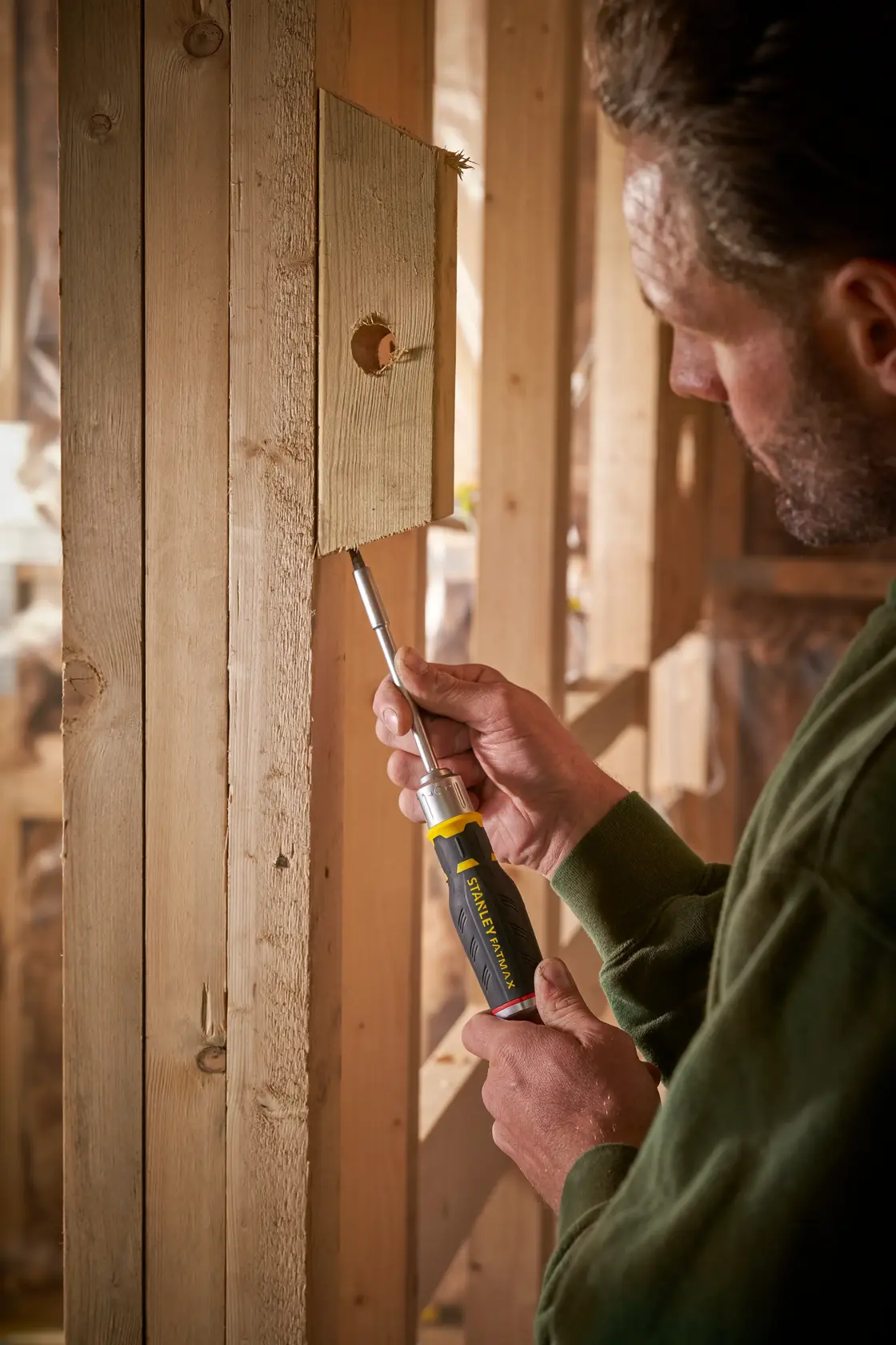STANLEY FMHT0-62690 Schraubendreher im Einsatz an Holz von Person, Nahaufnahme innen.