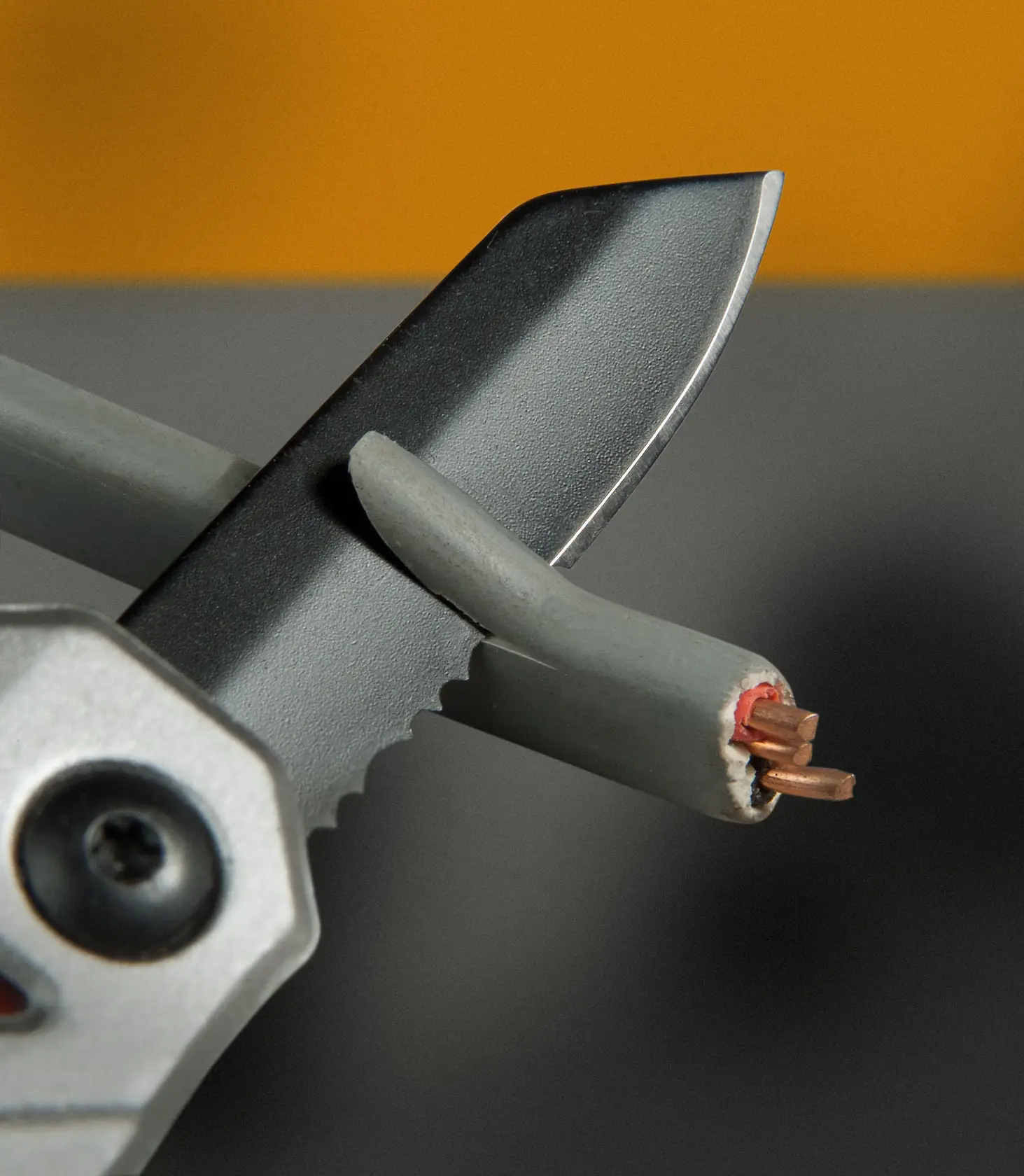 STANLEY FMHT0-72414 Wellenschliffklinge schneidet Elektrokabel, Nahaufnahme.