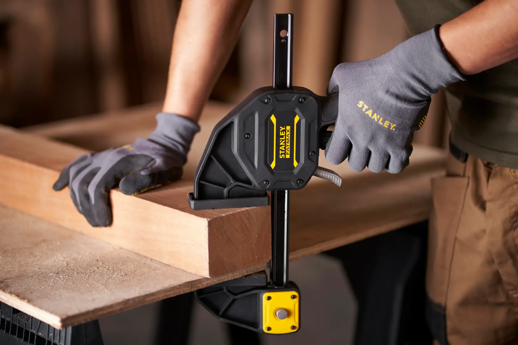 Stanley FMHT0-83238 Fotografie einer Einhandzwinge, die Holz auf einer Werkbank fixiert.