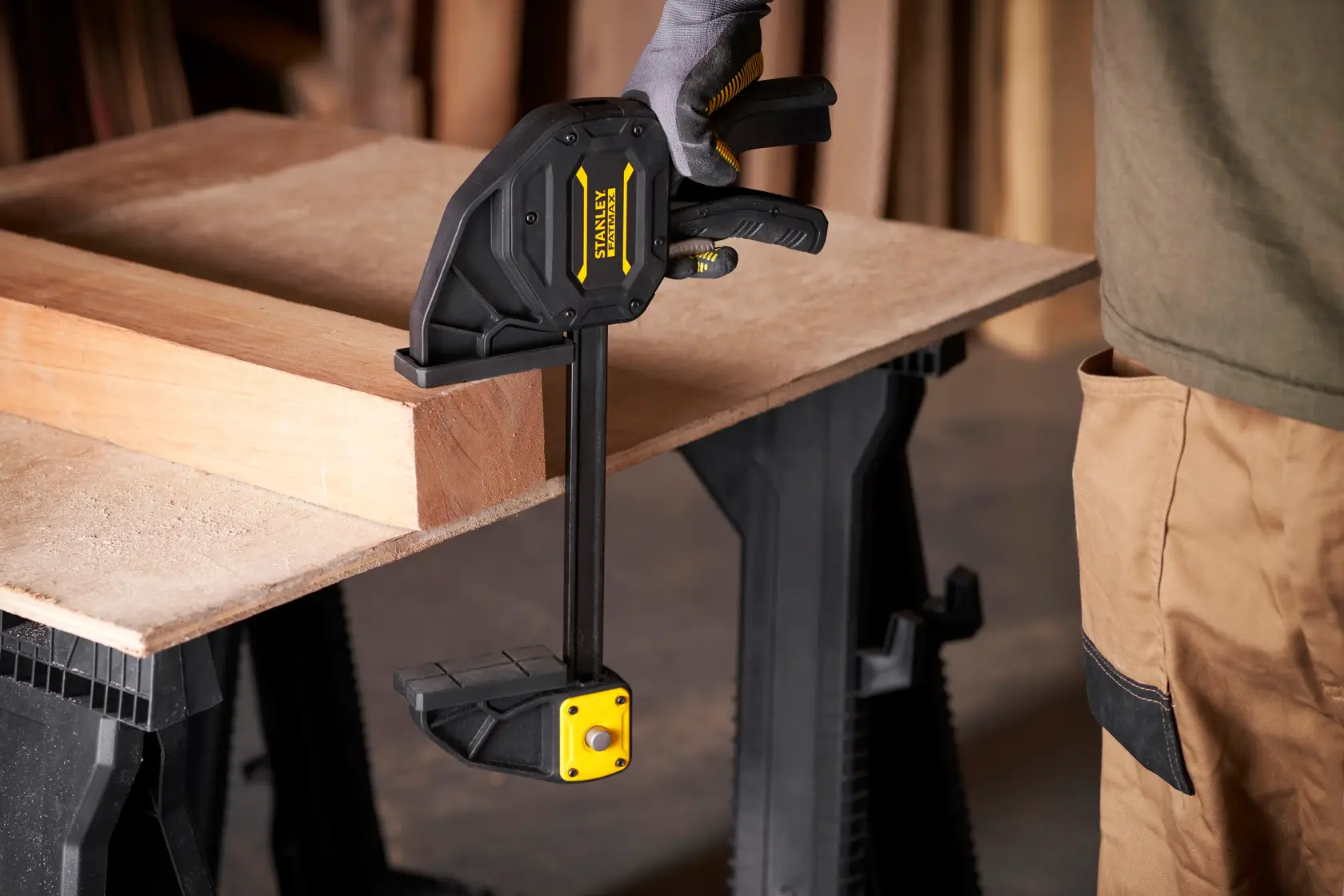 Stanley FMHT0-83238 Schnellspannzwinge fixiert Holz auf Werkbank, Seitenansicht.