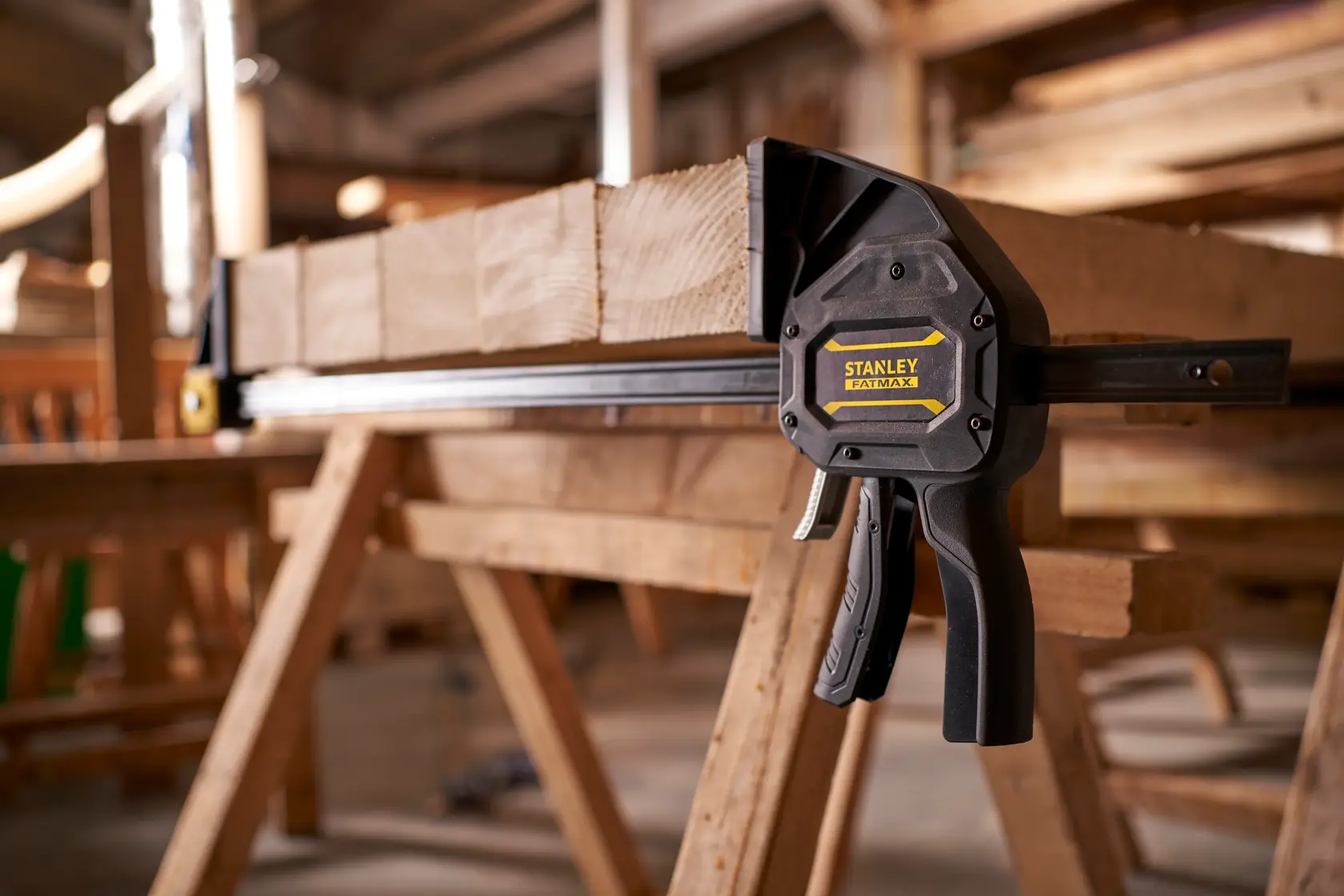 STANLEY FMHT0-83240 Schraubzwinge hält Holz auf Werkbank in Werkstatt, Seitenansicht.