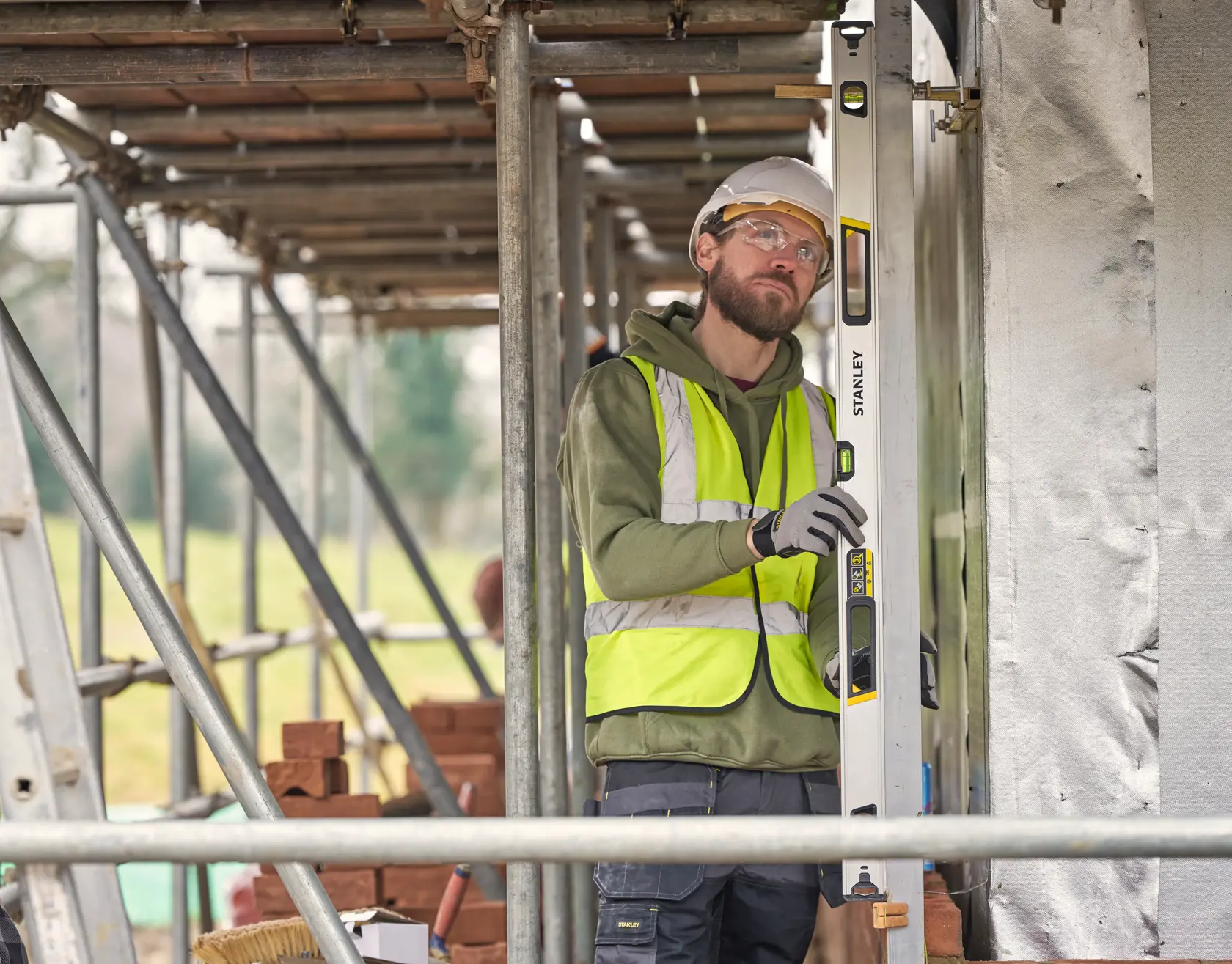 STANLEY FMHT43676-1 Wasserwaage wird vertikal von Bauarbeiter auf Baustelle verwendet.