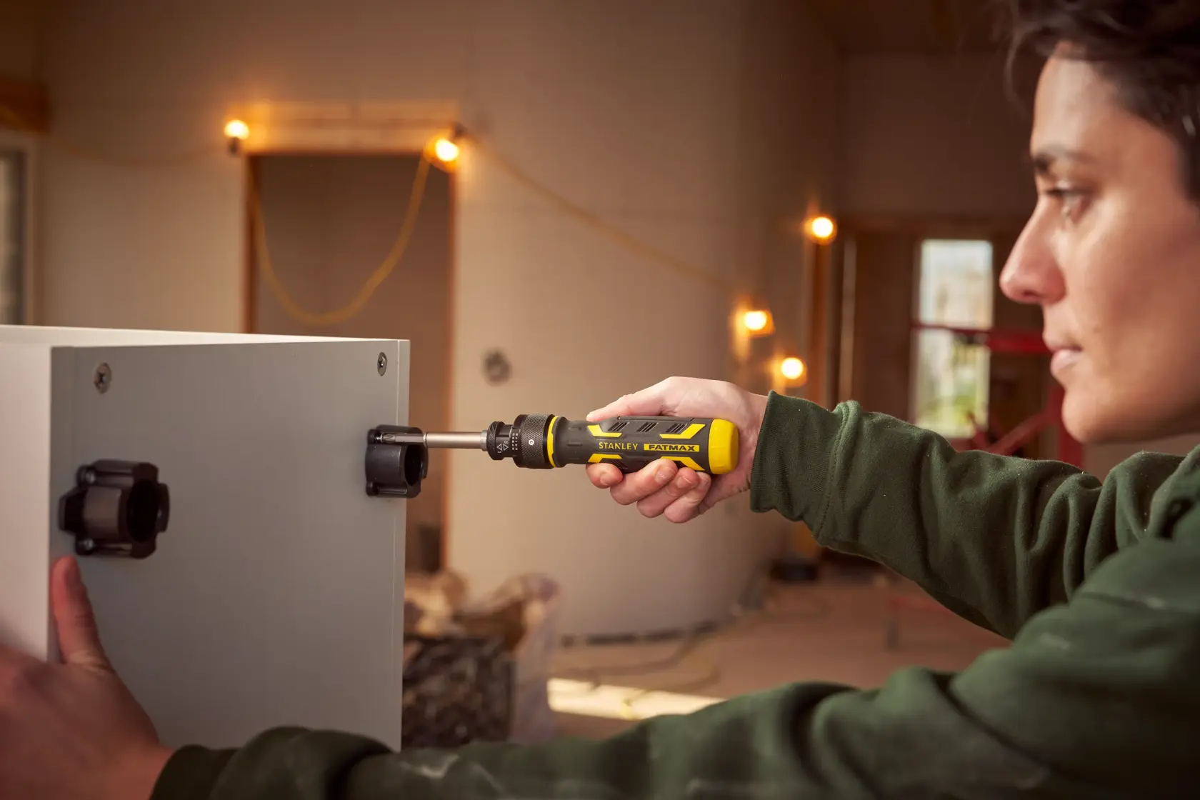 STANLEY FMHT62692-0 Ratschen-Schraubendreher im Einsatz an einem Schrank in einer Werkstatt.