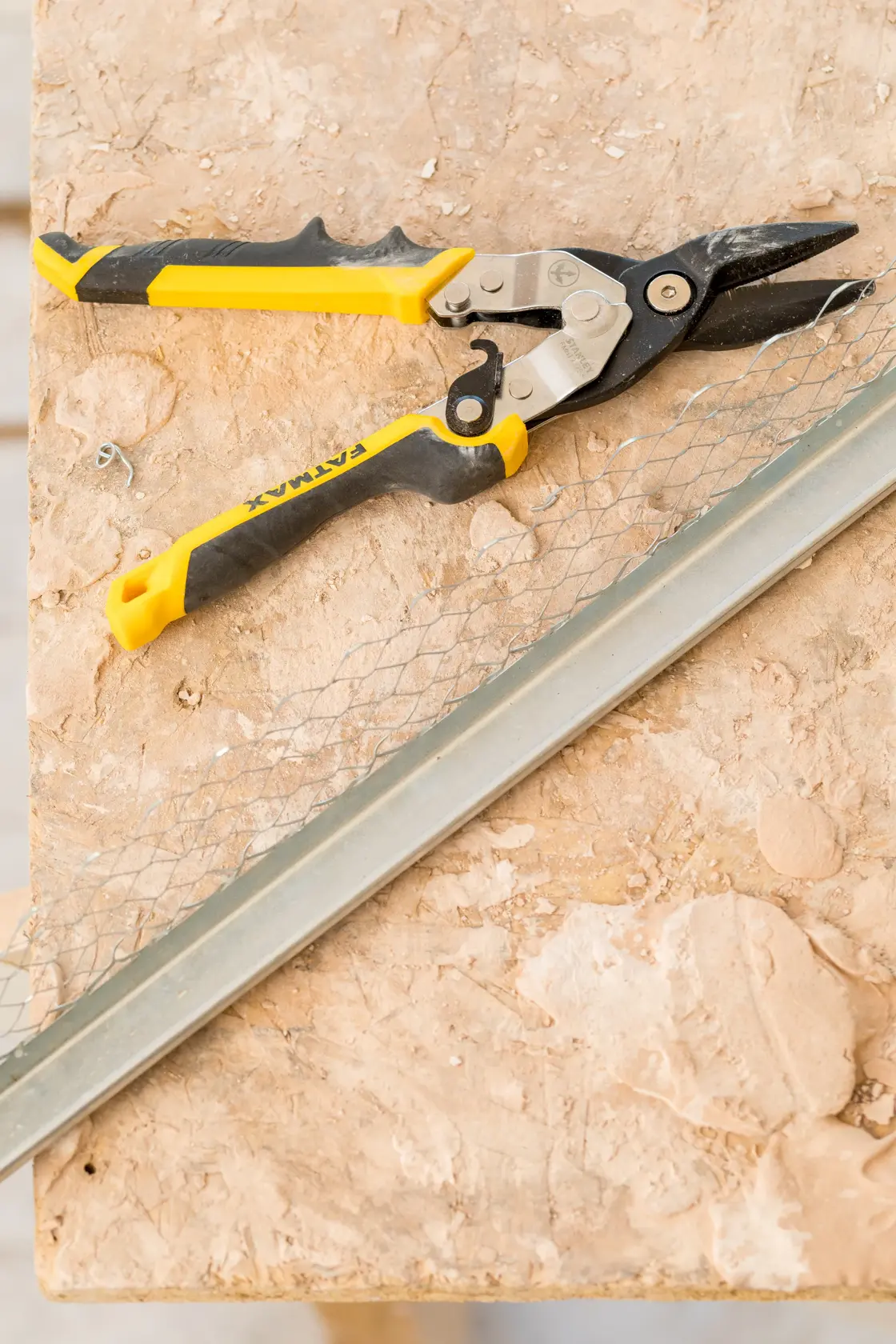 STANLEY FMHT73756-0 Blechschere mit gelb-schwarzem Griff auf Werkbank, aus der Vogelperspektive.