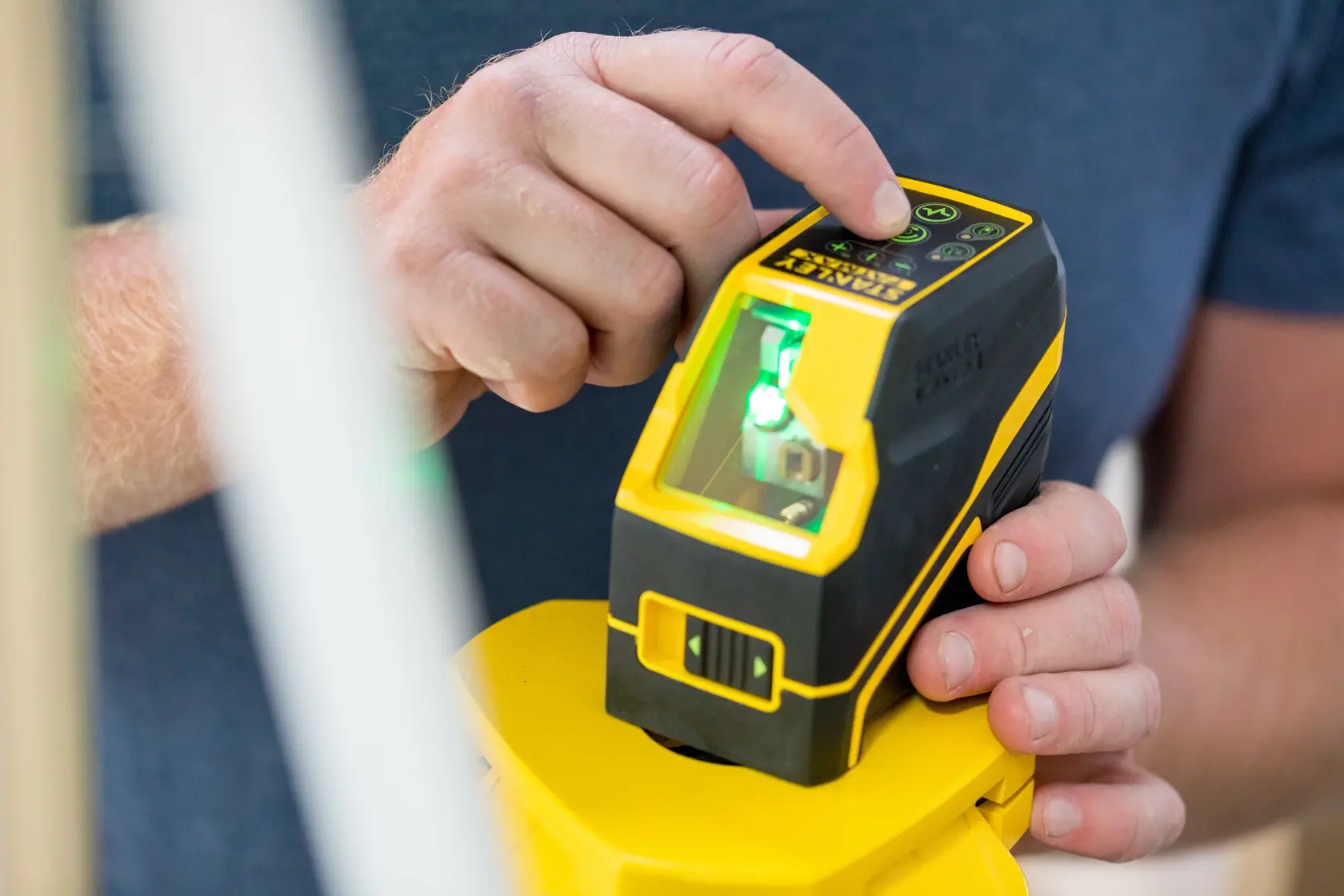 Foto vom STANLEY FMHT77586-1 Laser-Nivelliergerät in Gebrauch, gelbes und schwarzes Handwerkzeug mit Digitalsteuerung.