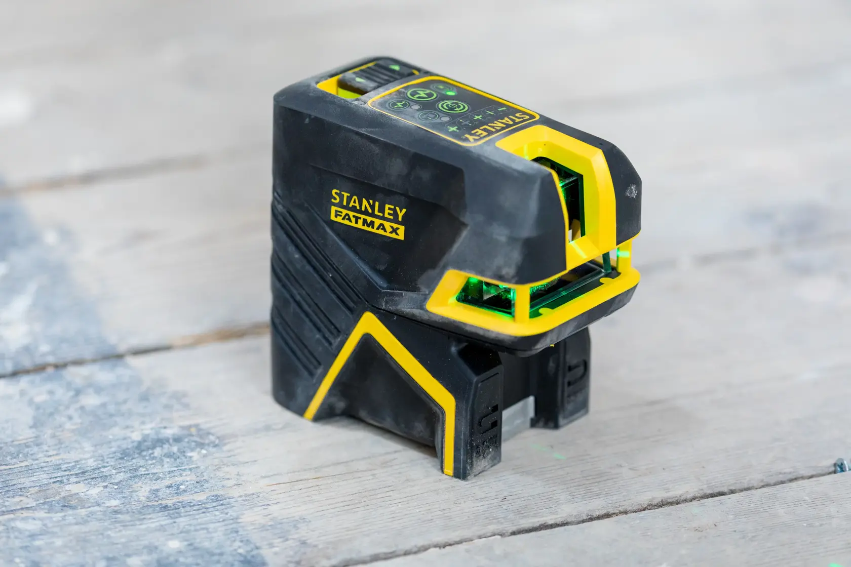 STANLEY FMHT77598-1 Laser-Nivelliergerät, schwarz und gelb, Fotografie des Werkzeugs auf Holzoberfläche.