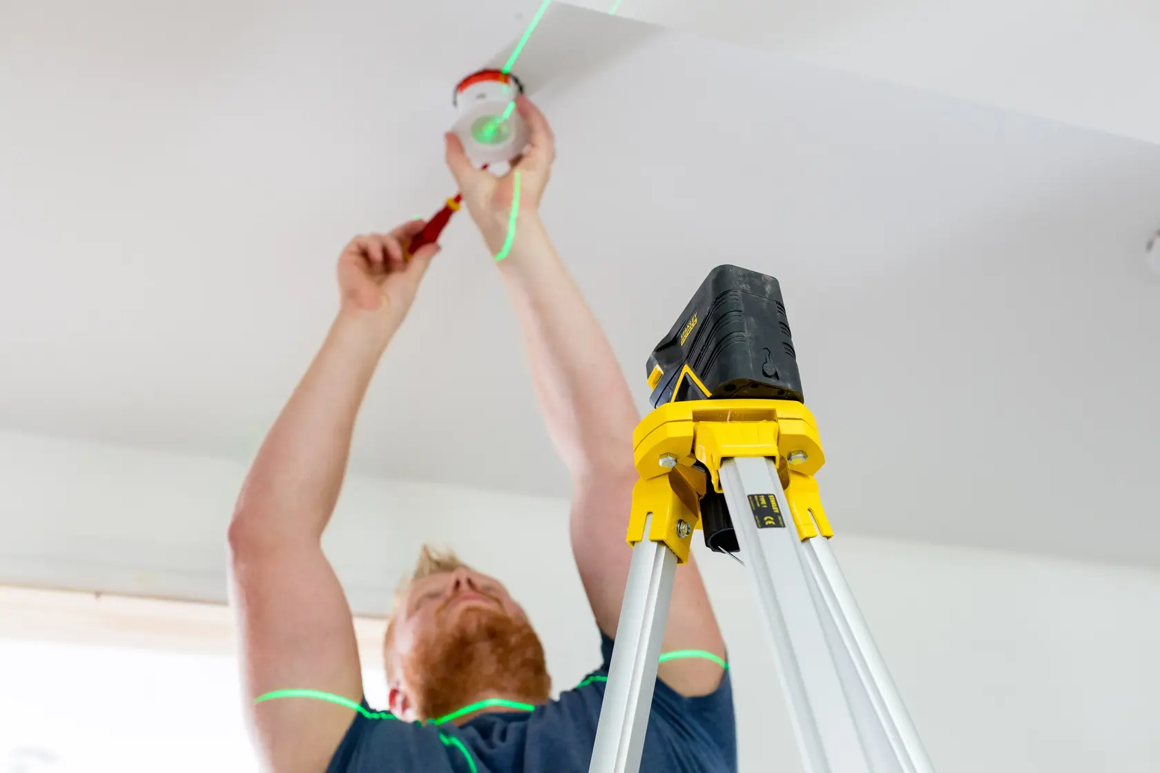 Foto des STANLEY FMHT77598-1 Laserniveau-Stativs im Einsatz bei einer Deckenmontage.