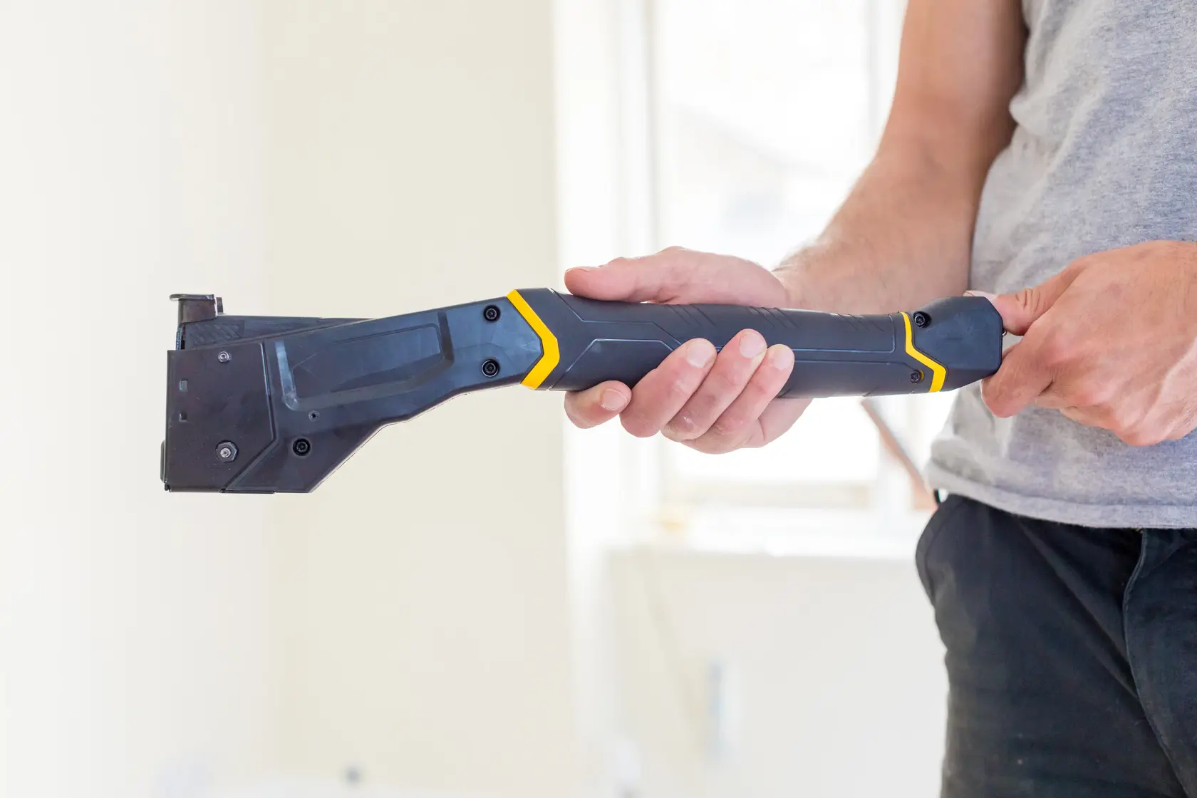STANLEY FMHT81394-9 robuster Tacker in der Hand, schräge Ansicht, schwarzes und gelbes Design.