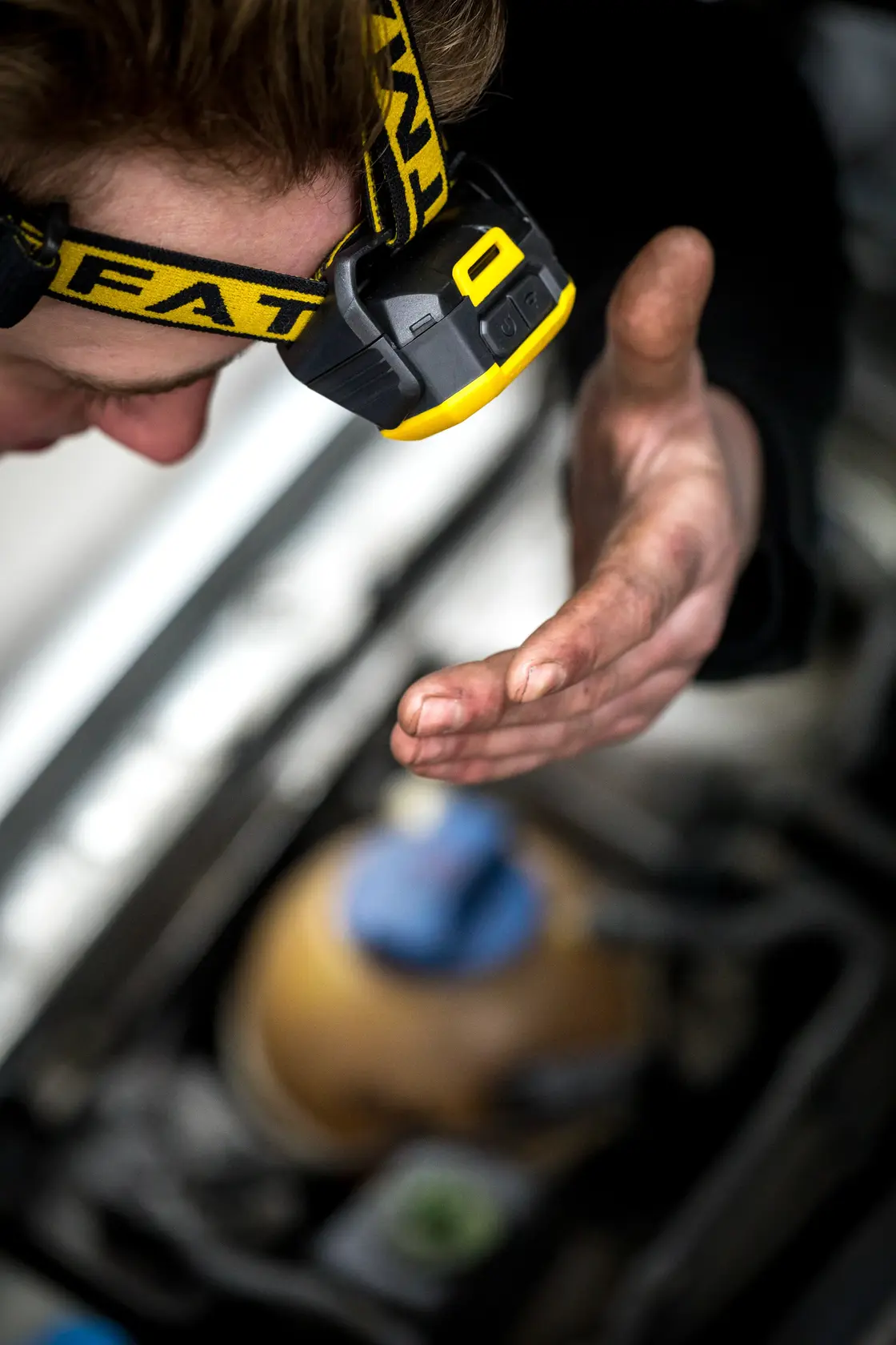 STANLEY FMHT81509-0 Stirnlampe an Person bei Arbeit, gelb-schwarz, Nahaufnahme Fotografie.